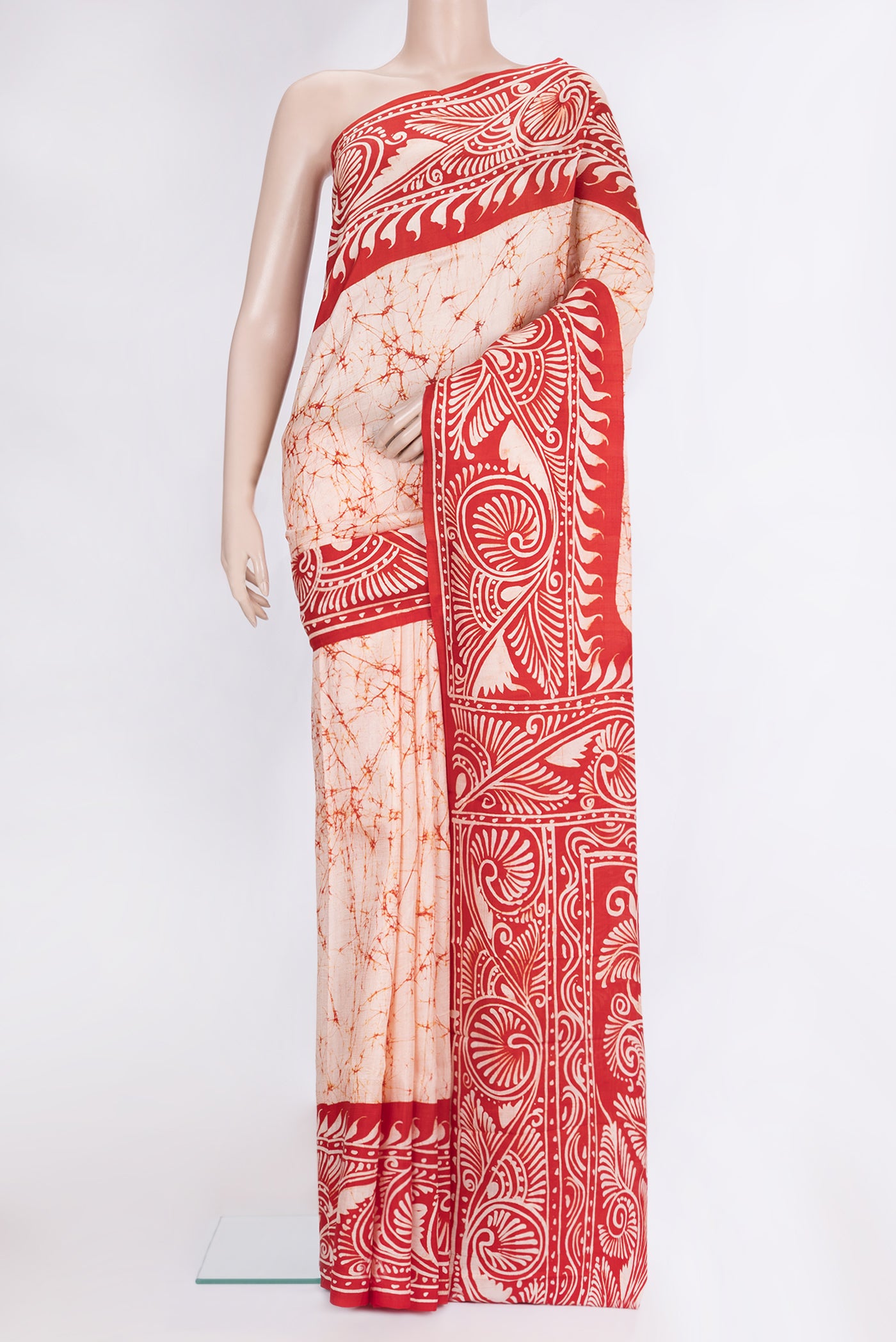 Peach Printed Silk Saree with Batik Print on the body and Printed Border.  displayed on a mannequin