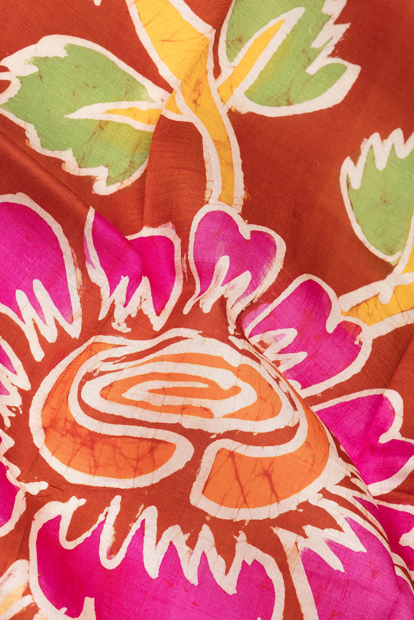 Close up of Rust Printed Silk Saree with Printed design on the body and Fancy Border.  displaying folds