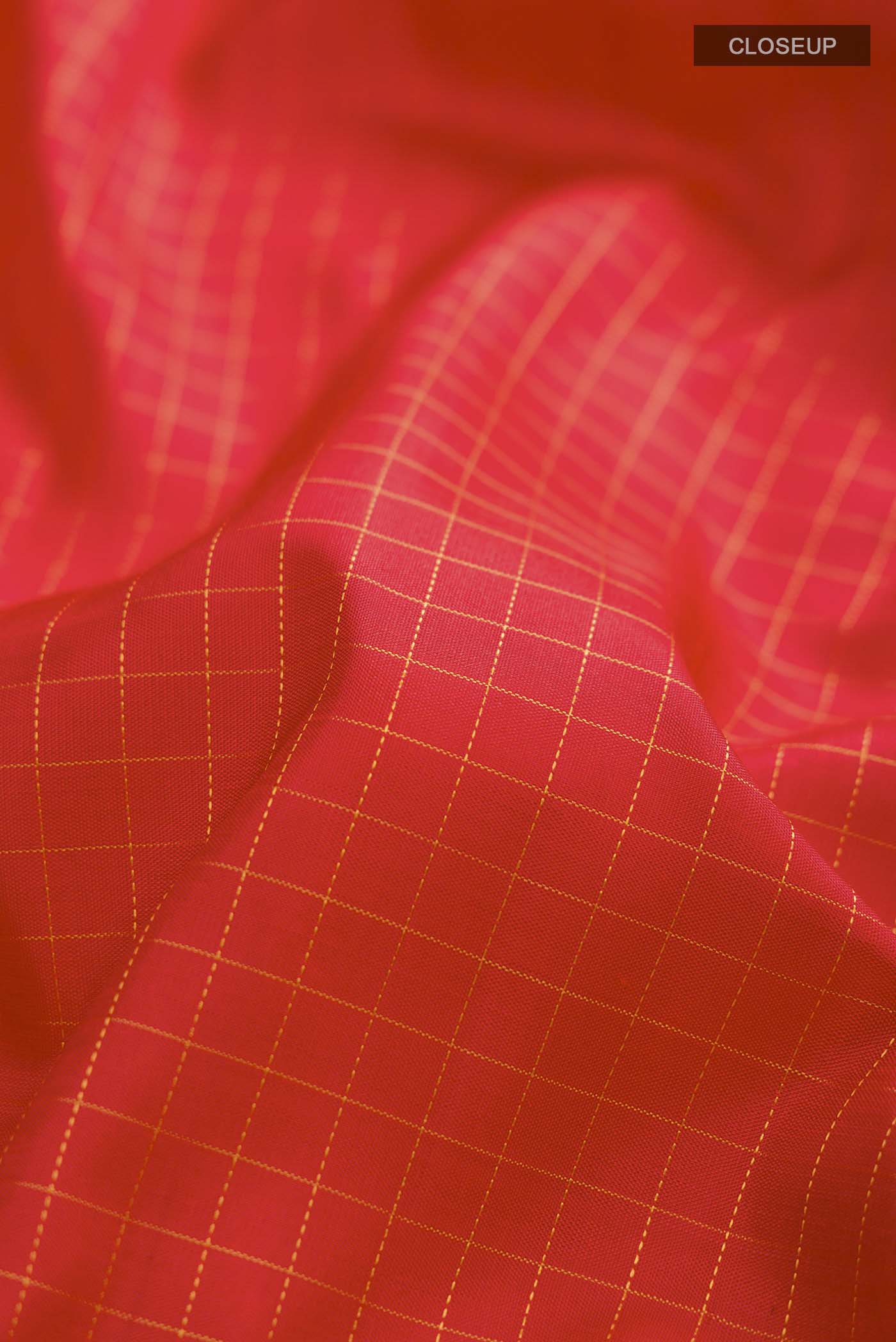 Close up of Red Kanchipuram Silk Saree Checked design on the body and Zari Border displaying folds