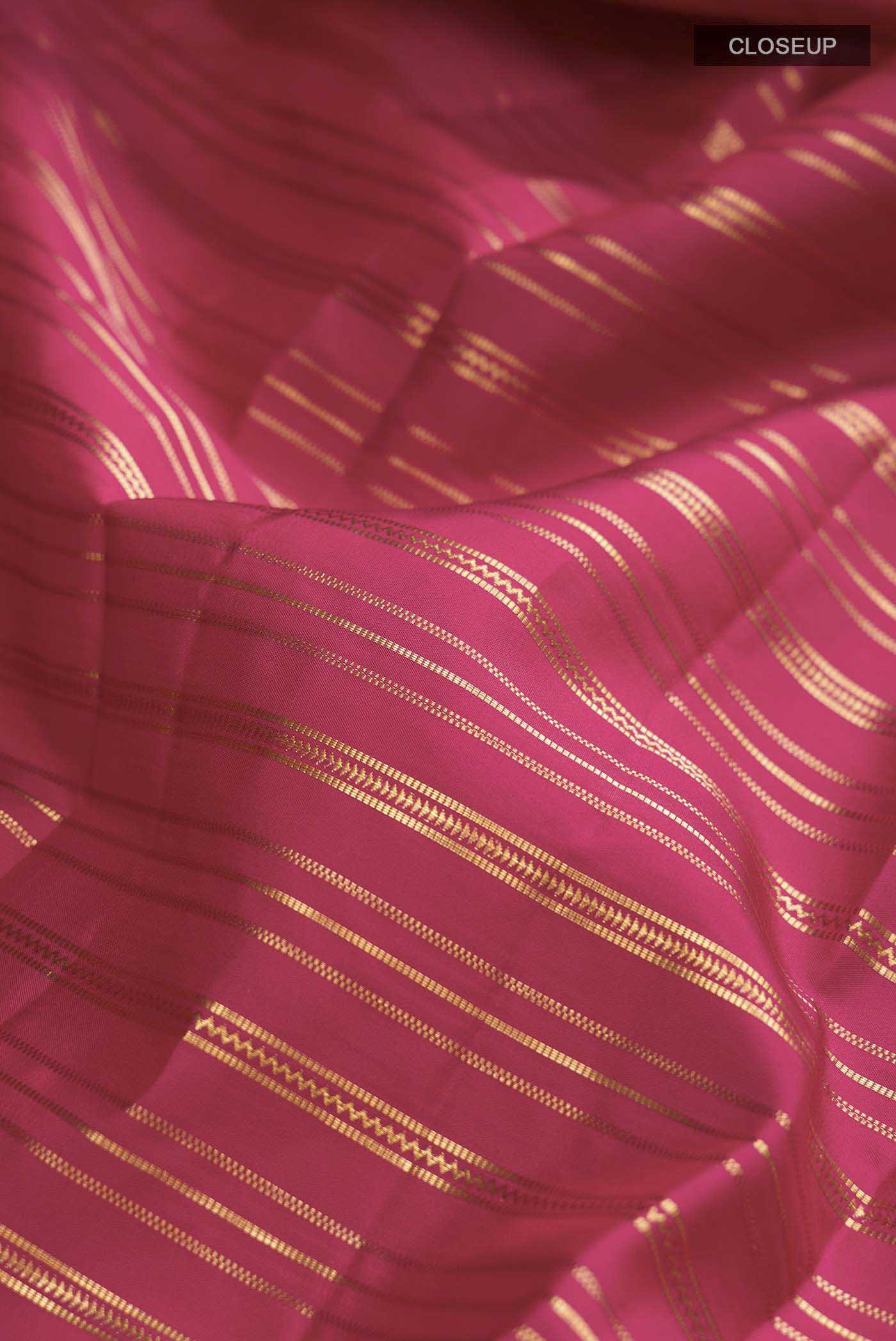 Close up of Maroon Kanchipuram Silk Saree with Stripes on the body and Zari Border displaying folds