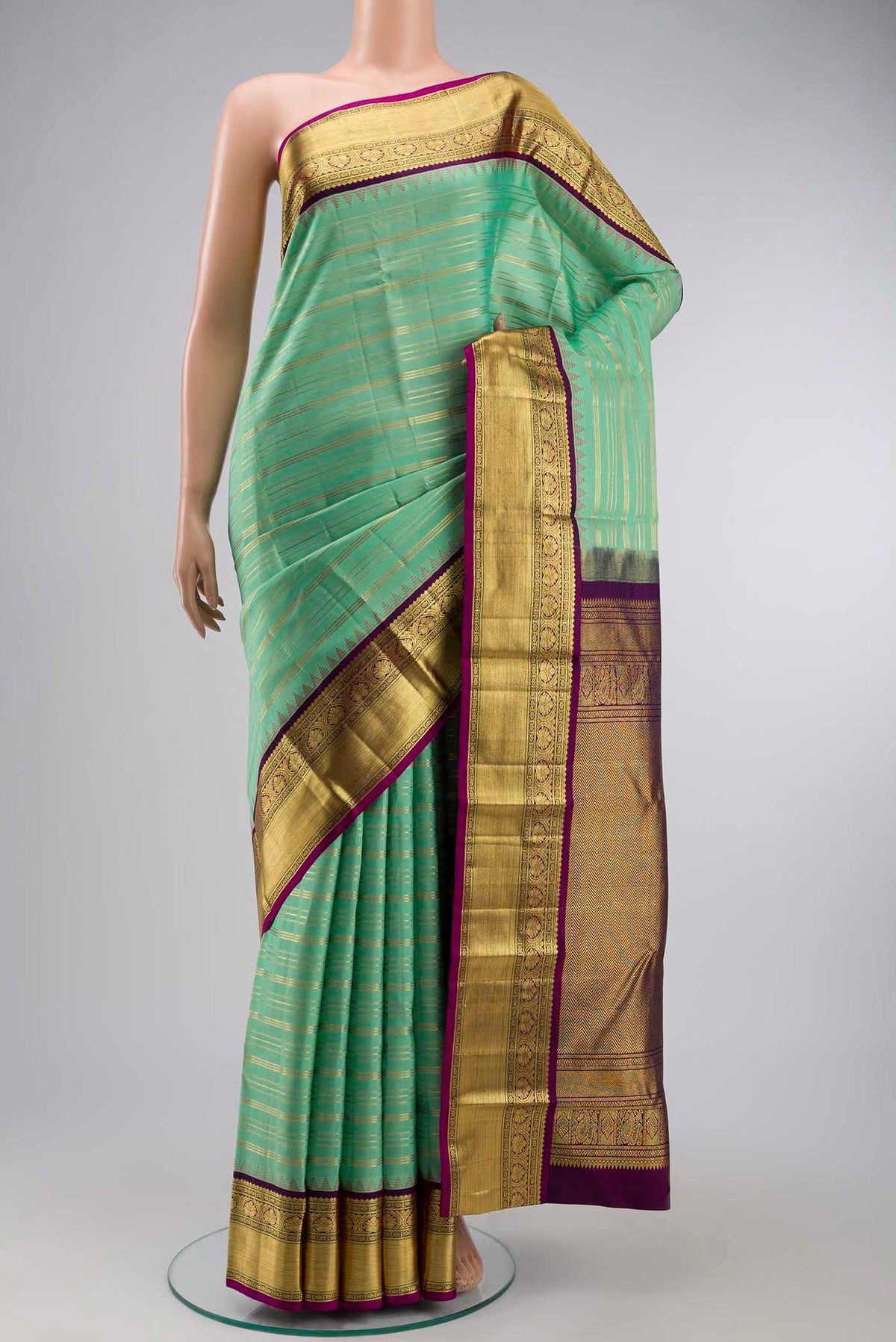 Green Kanchipuram Silk Saree with Stripes on the body and Zari Border displayed on a mannequin