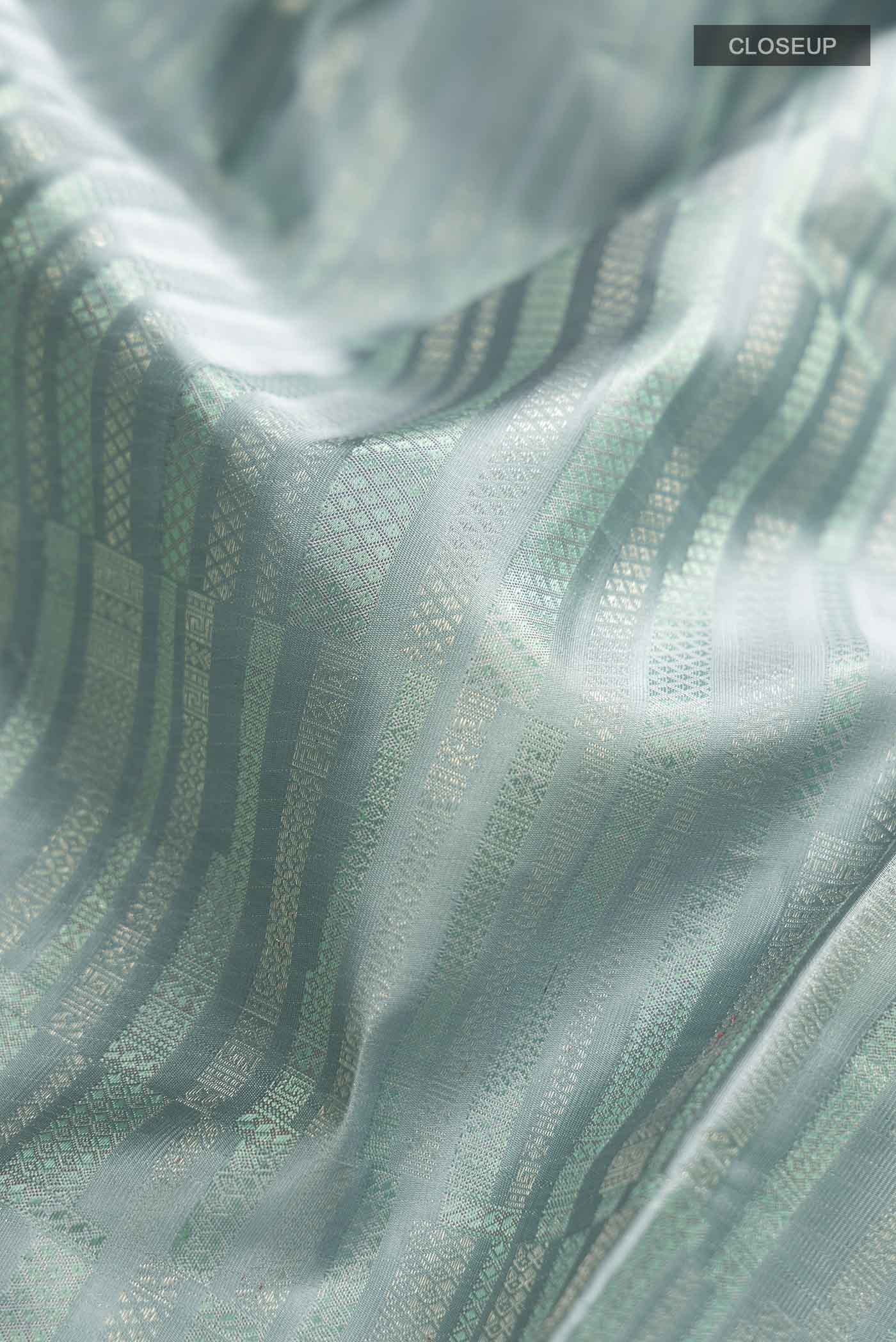 Close up of Blue Grey Kanchipuram Silk Saree with Stripes on the body and Zari Border displaying folds