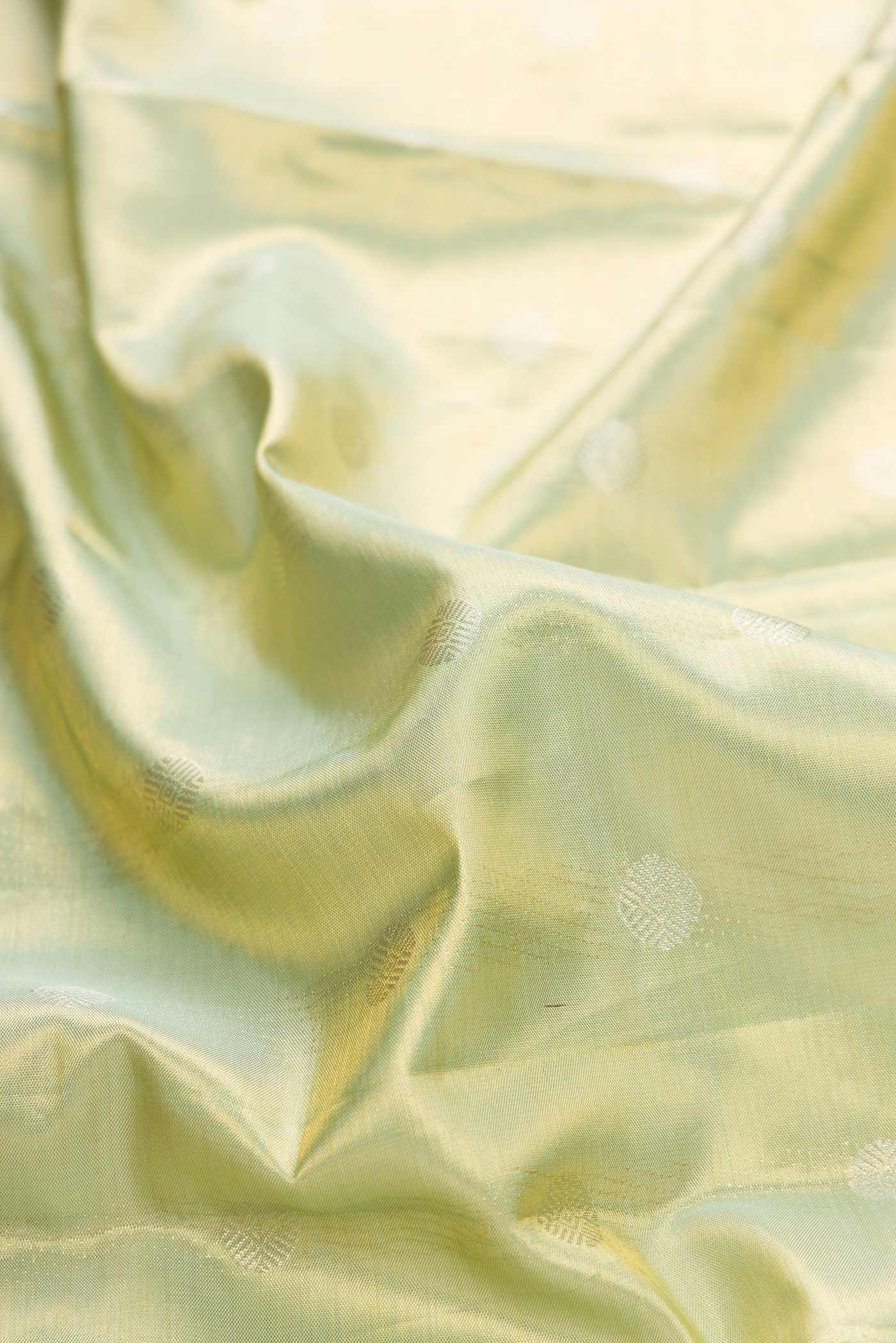 Close up of Pista Green Dual Tone Kanchipuram Tissue Silk Saree with Zari Brocade on the body and Zari Border displaying folds