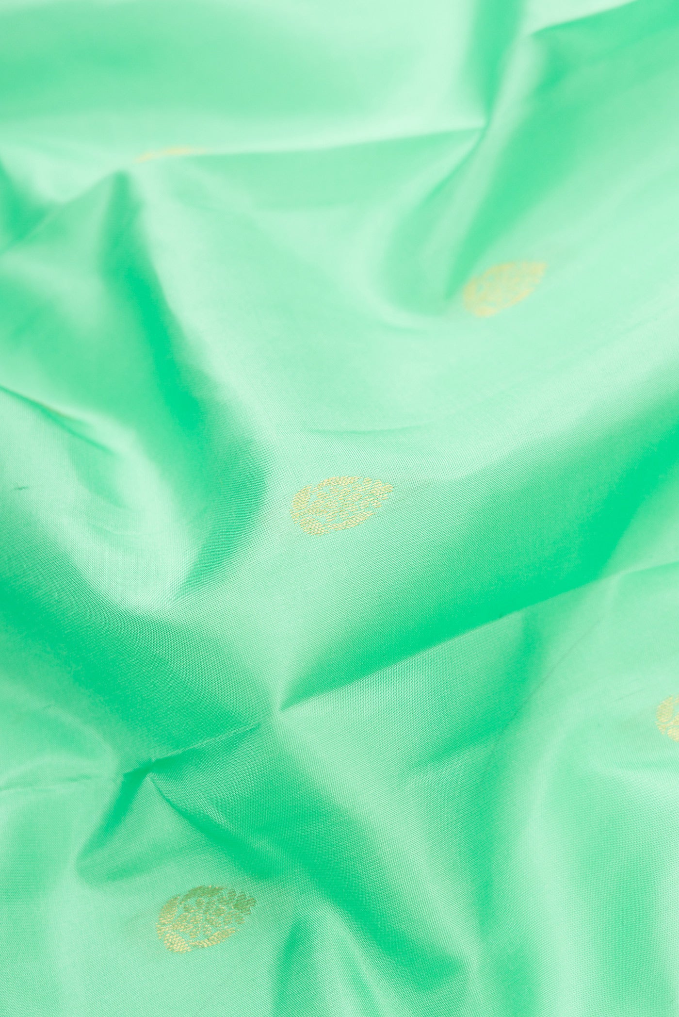 Close up of Pista Green Dual Tone Kanjivaram Silk Saree with Zari Butta on the body and Zari Border.  displaying folds