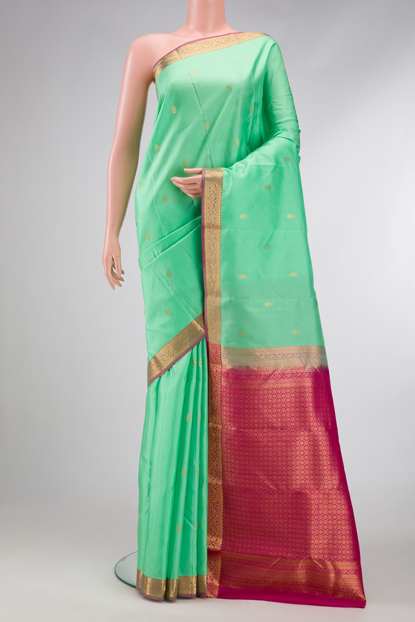 Pista Green Dual Tone Kanjivaram Silk Saree with Zari Butta on the body and Zari Border.  displayed on a mannequin