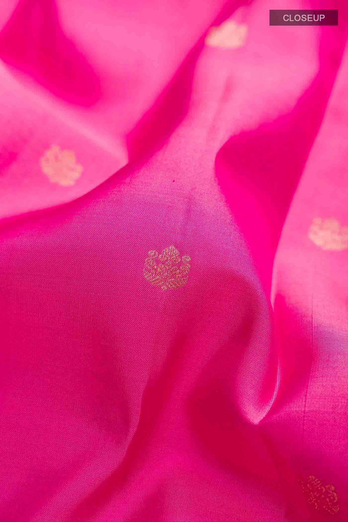 Close up of Pink Kanchipuram Silk Saree with Zari Butta on the body and Zari Border displaying folds