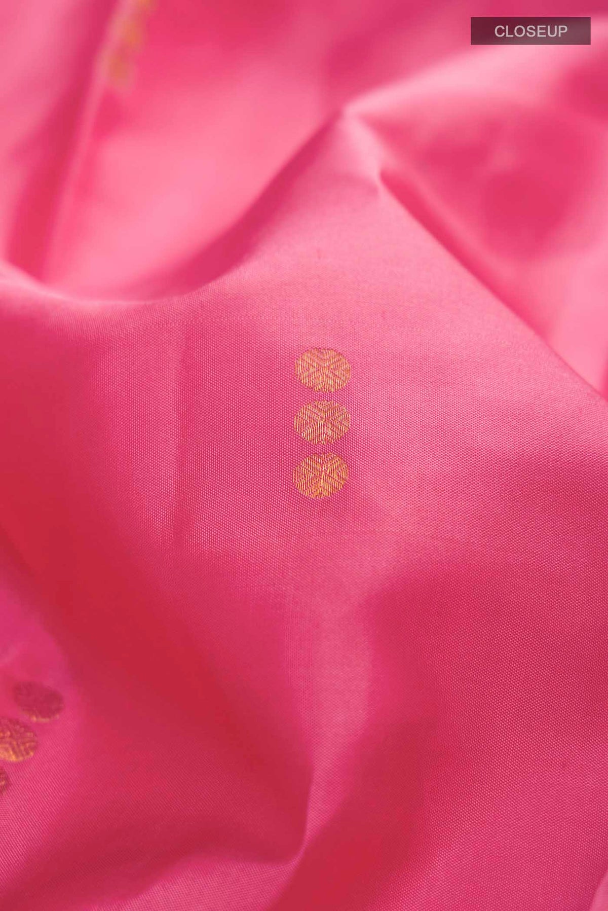 Close up of Pink Kanchipuram Silk Saree with Zari Butta on the body and Zari Border displaying folds