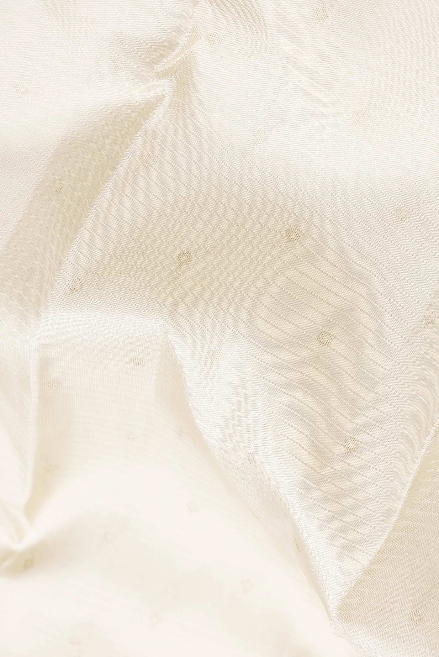 Close up of Off White Dual Tone Kanchipuram Silk Saree with Zari Butta on the body and Zari And Thread Border.  displaying folds