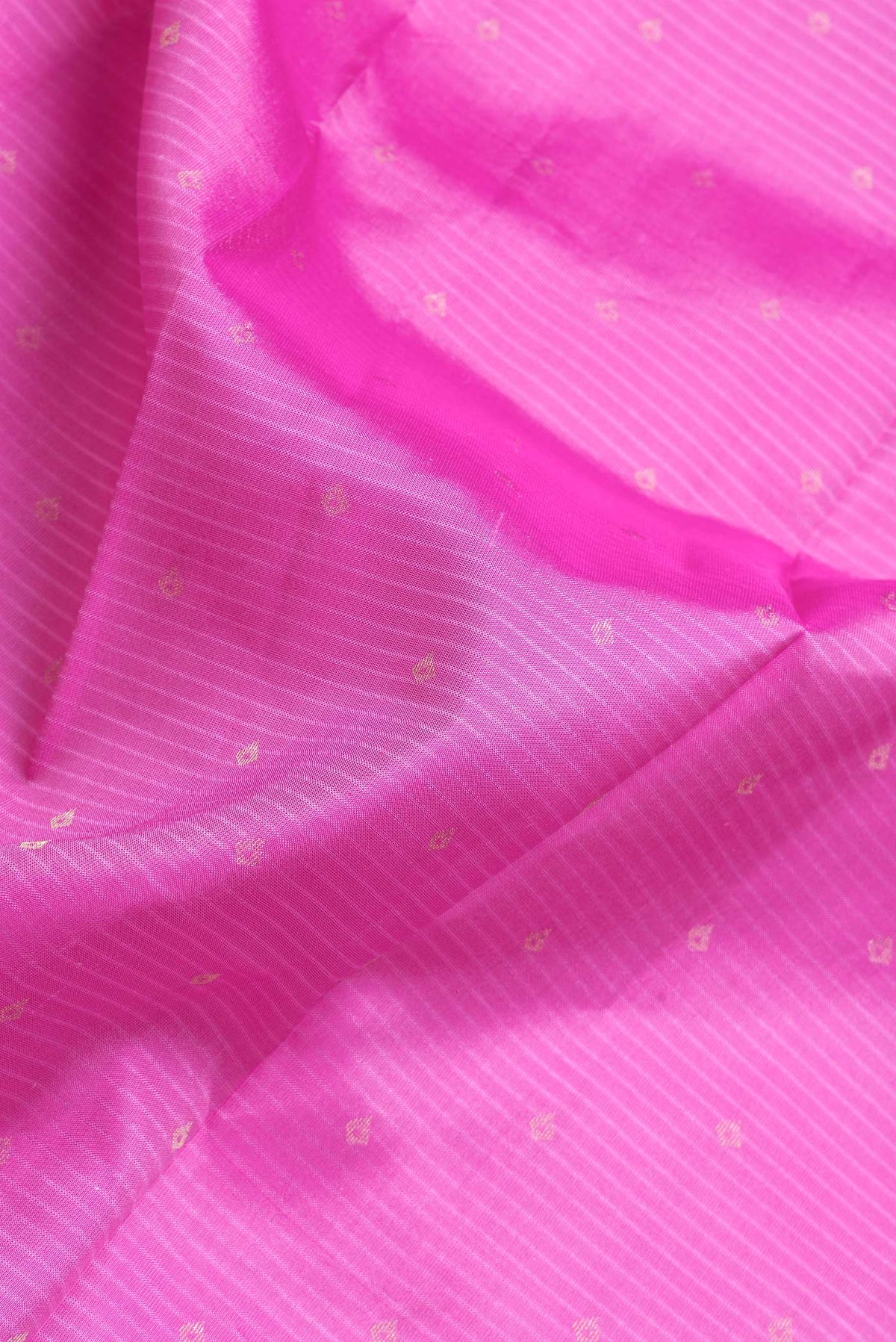 Close up of Pink Dual Tone Kanchipuram Silk Saree with Zari Butta on the body and Zari And Thread Border.  displaying folds
