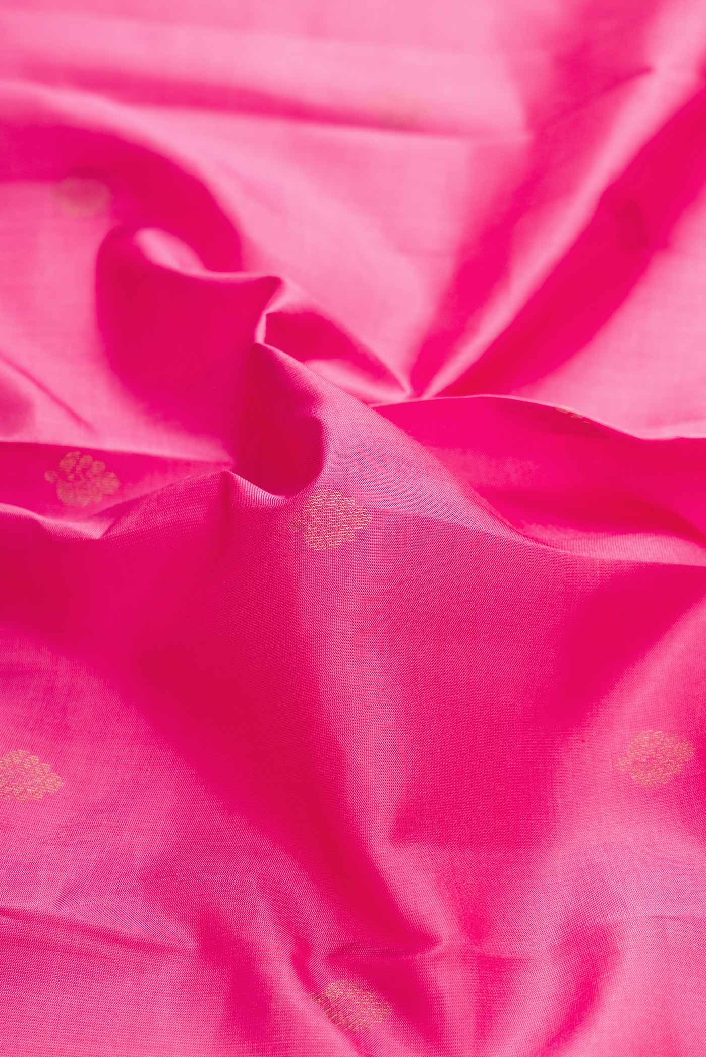 Close up of Pink Dual Tone Kanchipuram Silk Saree with Zari Butta on the body and Zari Border displaying folds