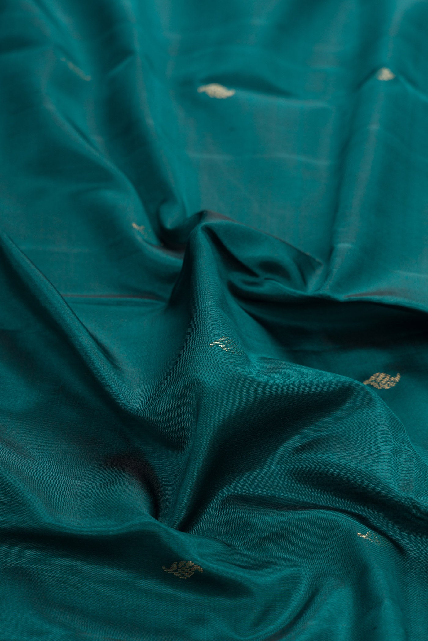 Close up of Maya Blue Dual Tone Kanchipuram Silk Saree with Zari Butta on the body and Zari Border.  displaying folds