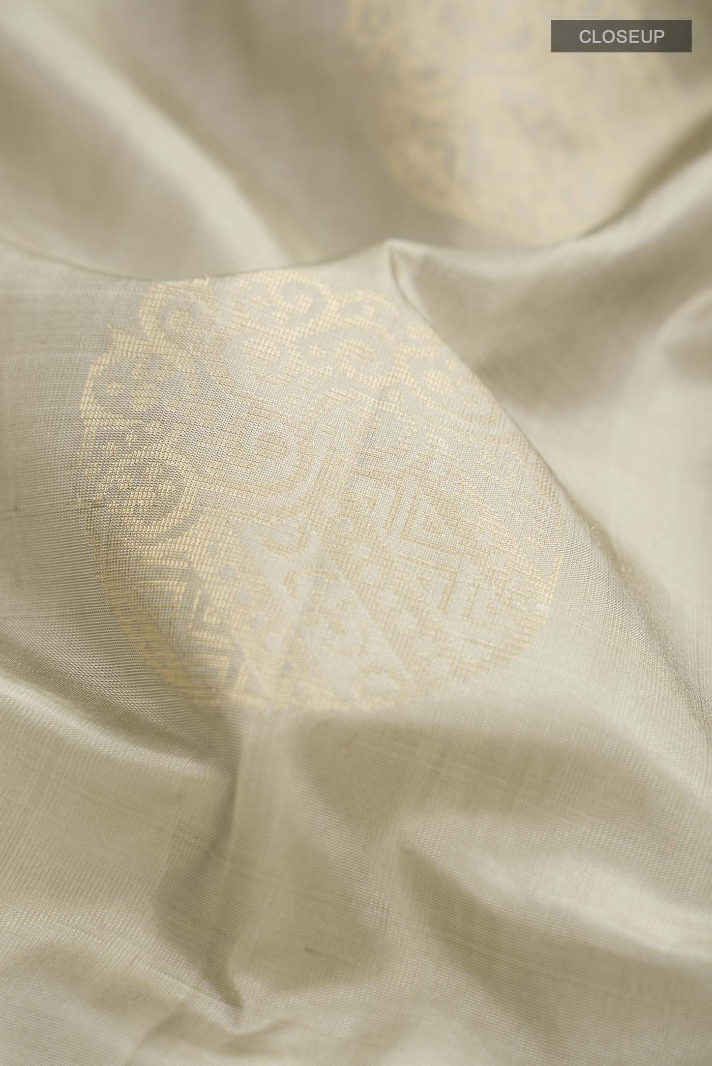 Close up of Green Soft Silk Saree with Zari Butta on the body and Zari Border displaying folds