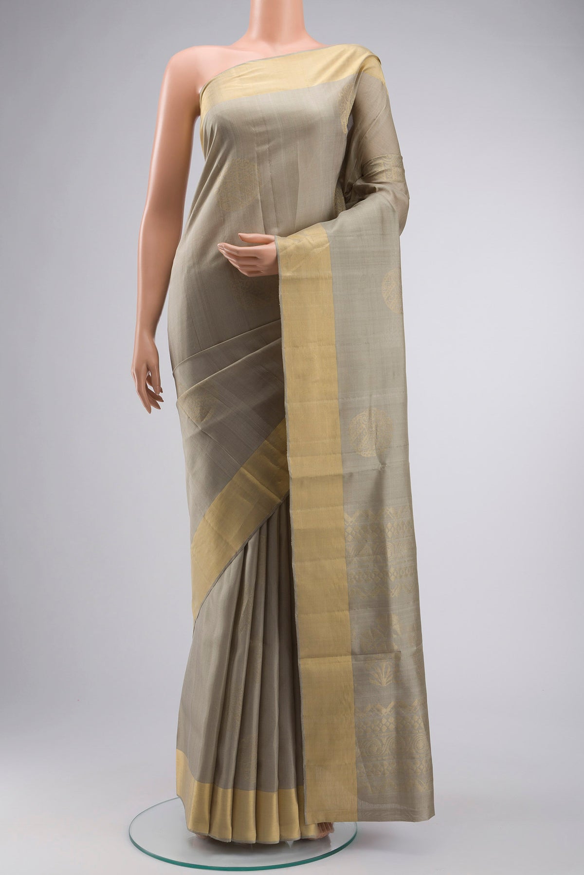 Green Soft Silk Saree with Zari Butta on the body and Zari Border displayed on a mannequin