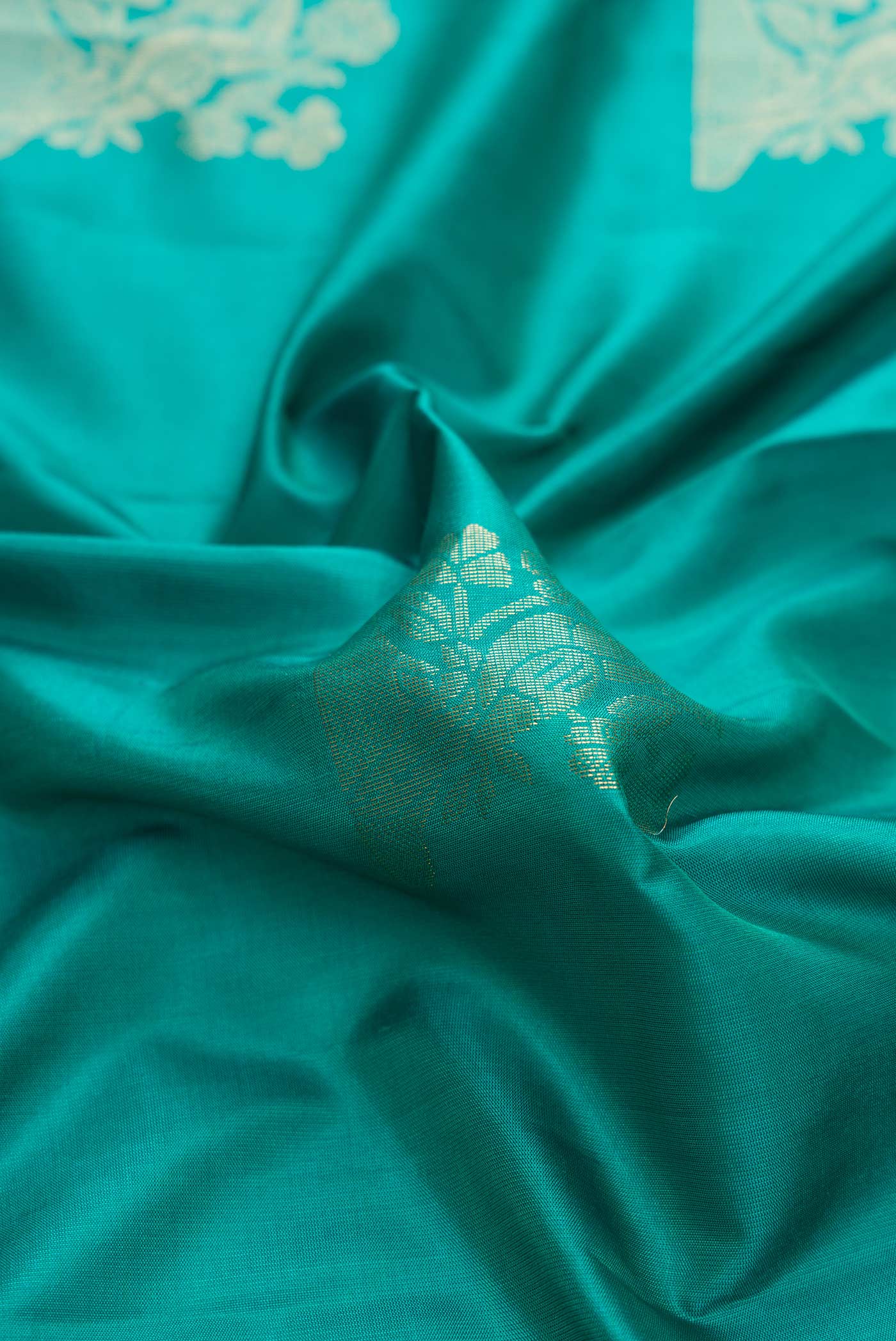Close up of Blue Dual Tone Soft Silk Saree with Zari Butta on the body and Zari Border displaying folds