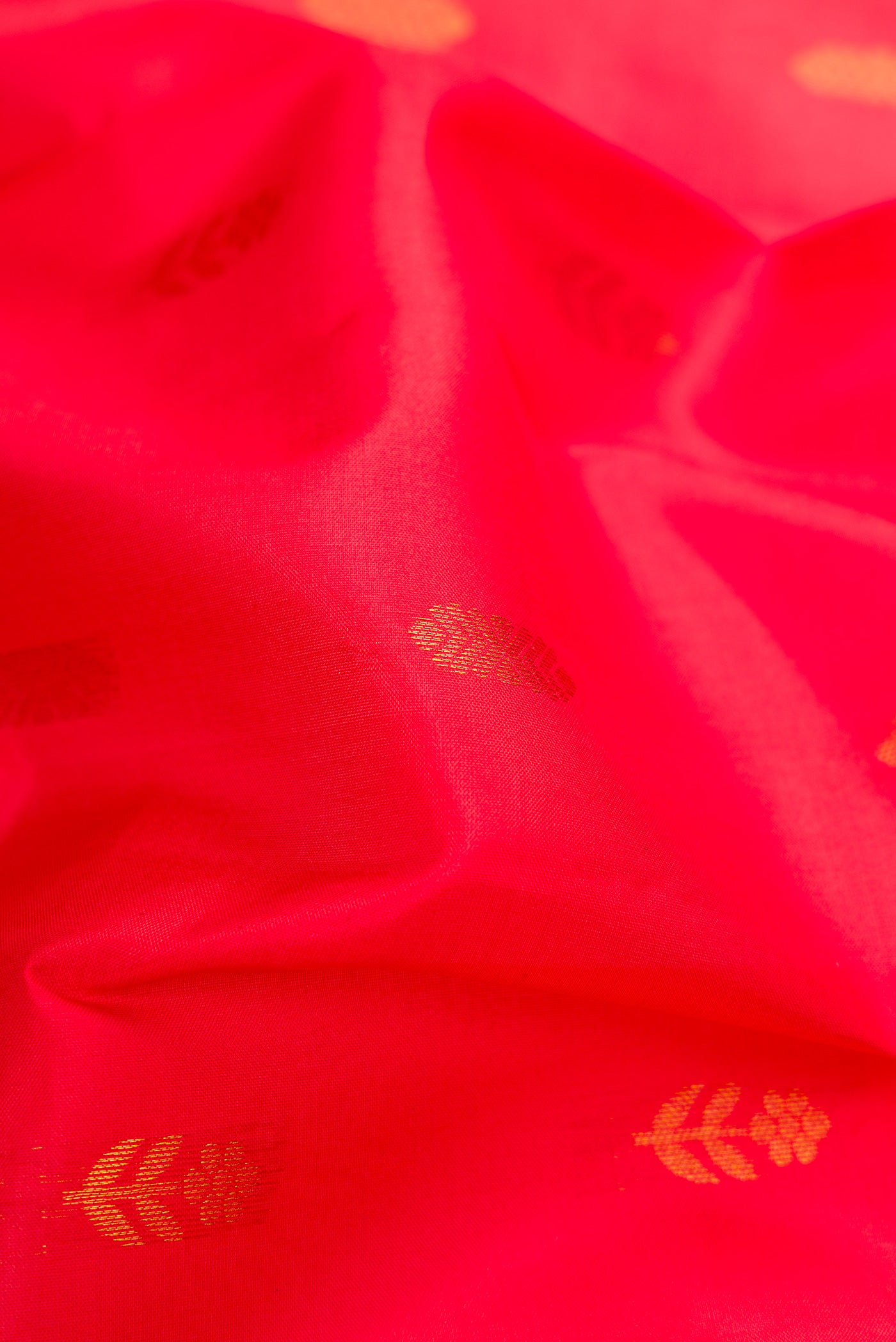 Close up of Red Kanchipuram Silk Saree with Zari Butta on the body and Zari Border.  displaying folds