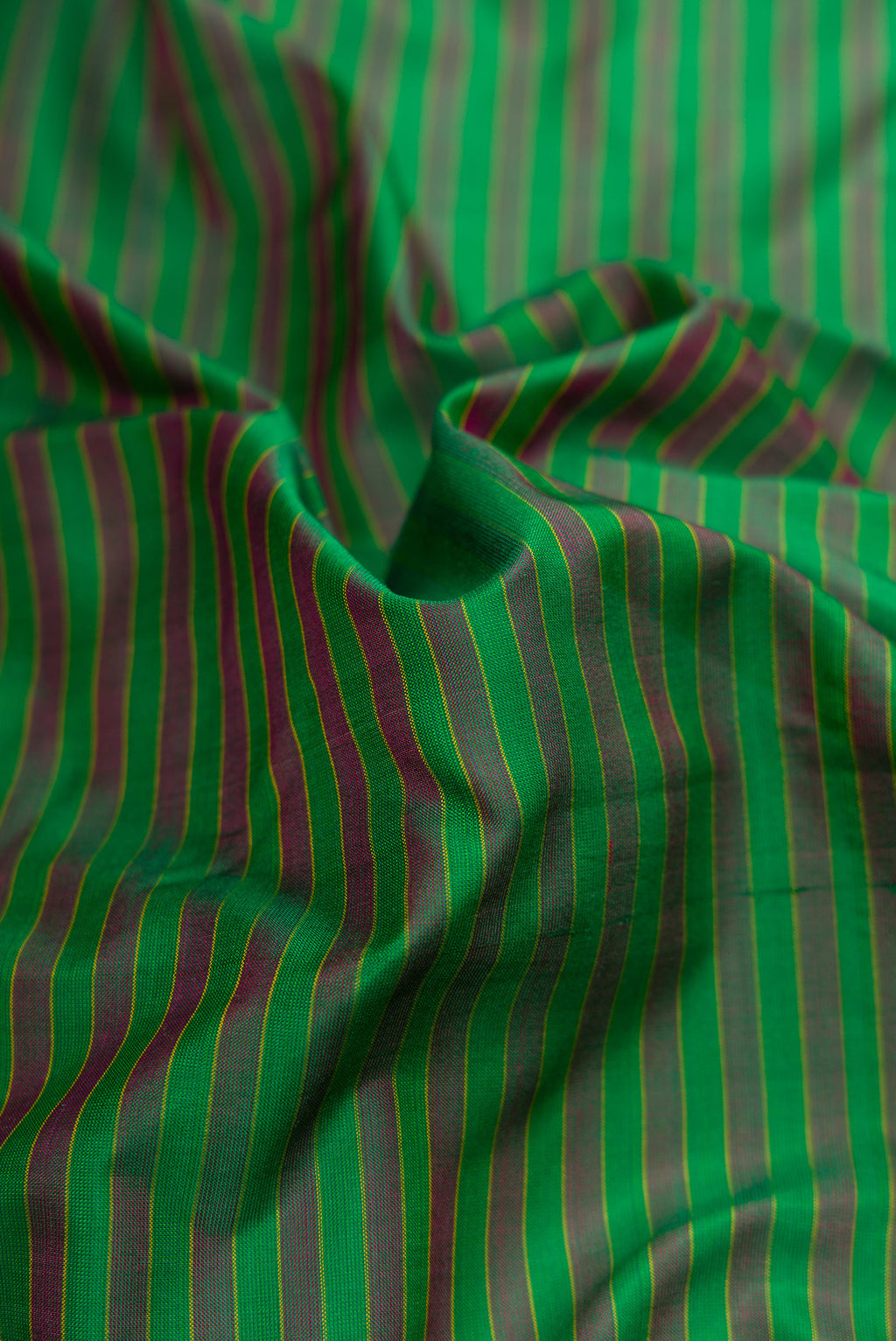 Close up of Green Dual Tone Kanjivaram Silk Saree with Stripes on the body and Zari Border.  displaying folds