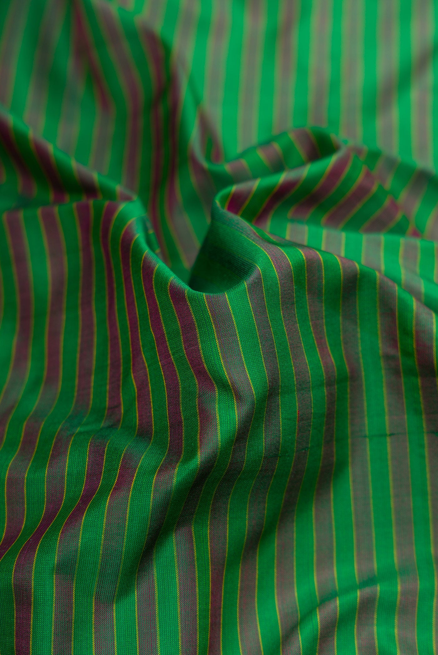 Close up of Green Dual Tone Kanjivaram Silk Saree with Stripes on the body and Zari Border.  displaying folds