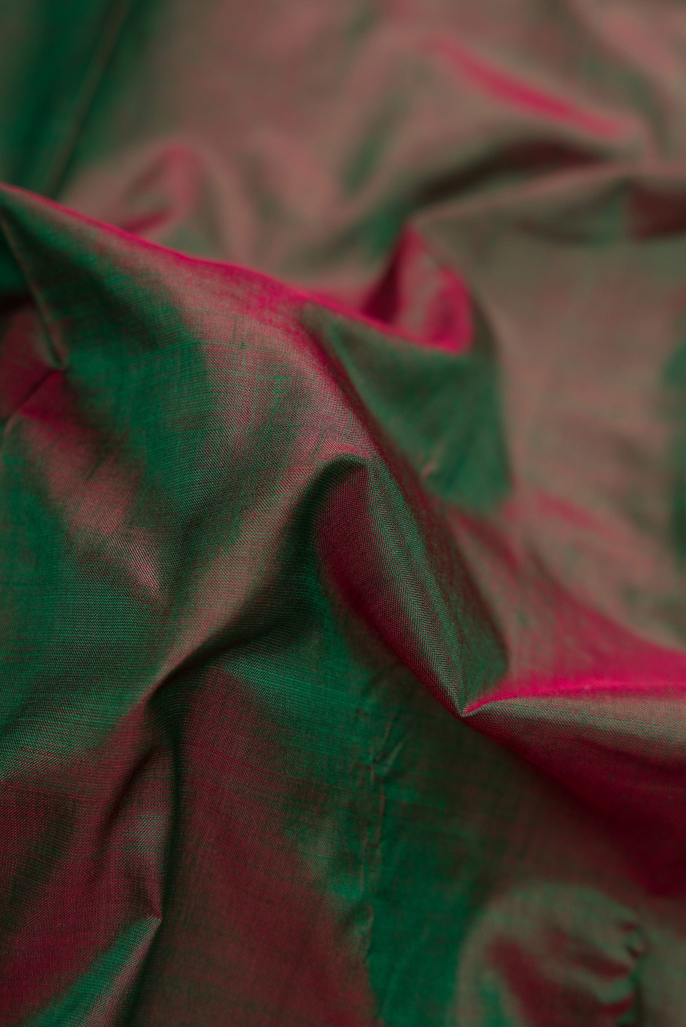 Close up of Green Dual Tone Kanchipuram Silk Saree with Plain Body and Zari Border.  displaying folds
