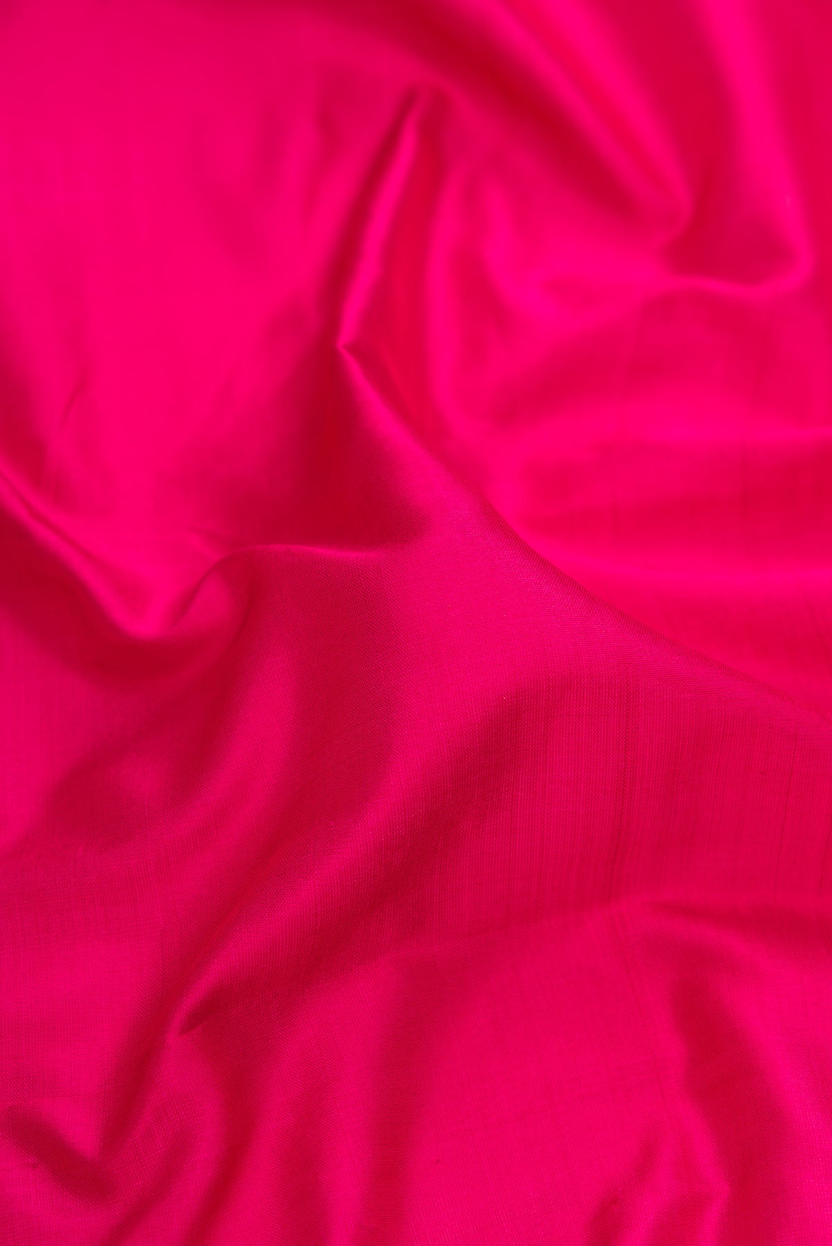 Close up of Dark Pink Kanchipuram Silk Saree with Plain Body and Thread Border.  displaying folds
