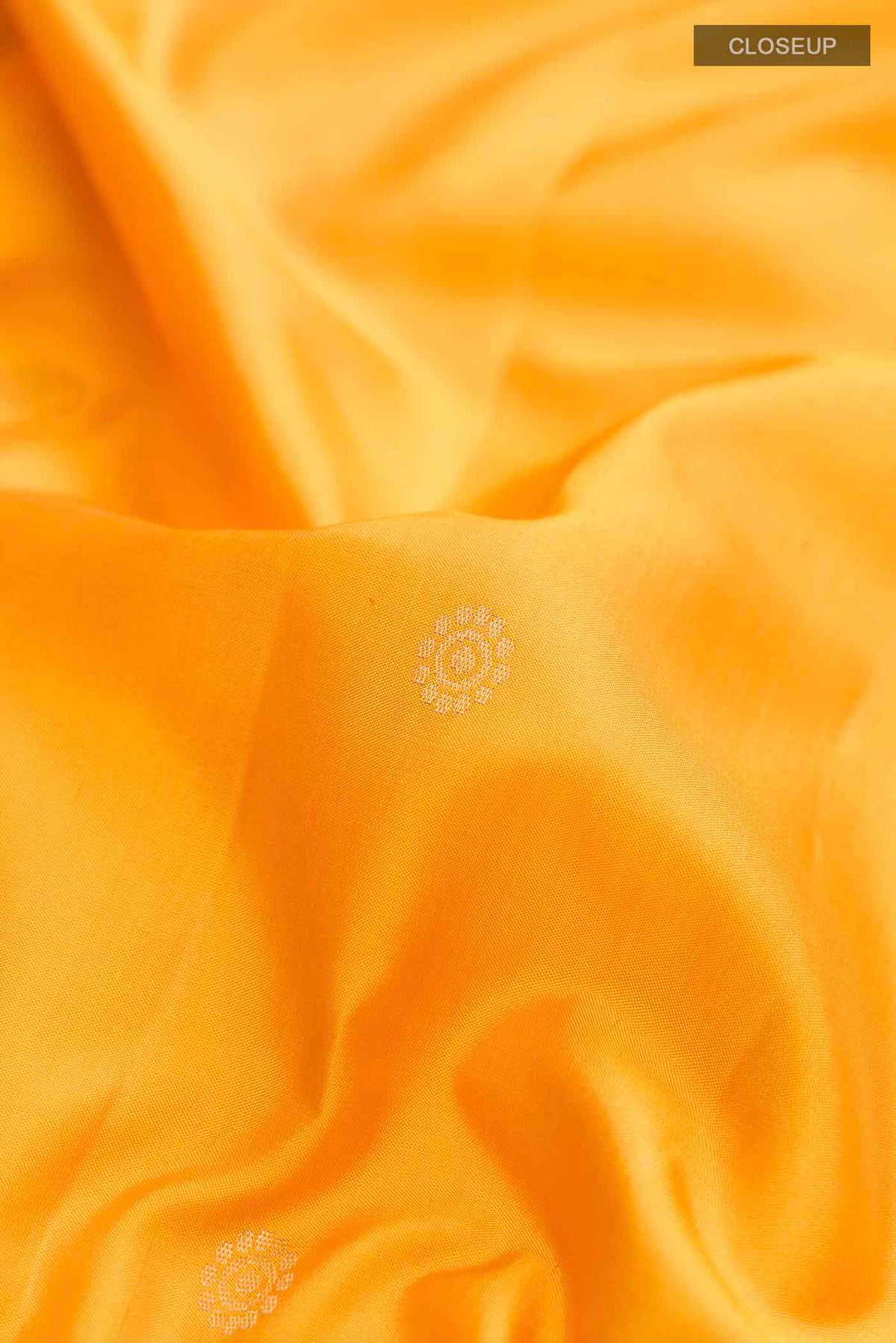 Close up of Yellow Soft Silk Saree with Zari Butta on the body and Zari Border displaying folds