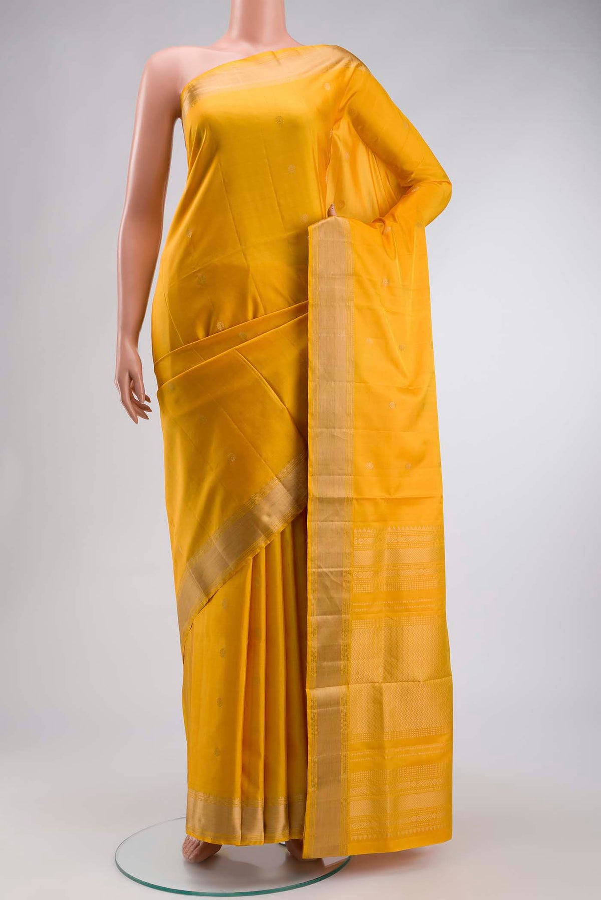 Yellow Soft Silk Saree with Zari Butta on the body and Zari Border displayed on a mannequin