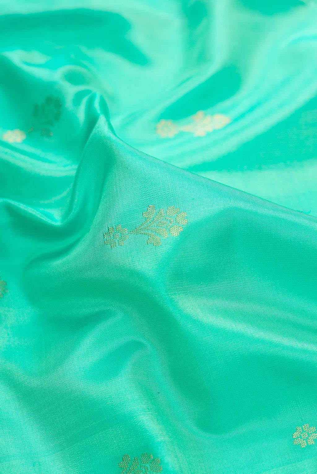 Close up of Sea Green Dual Tone Soft Silk Saree with Zari Butta on the body and Zari Border.  displaying folds