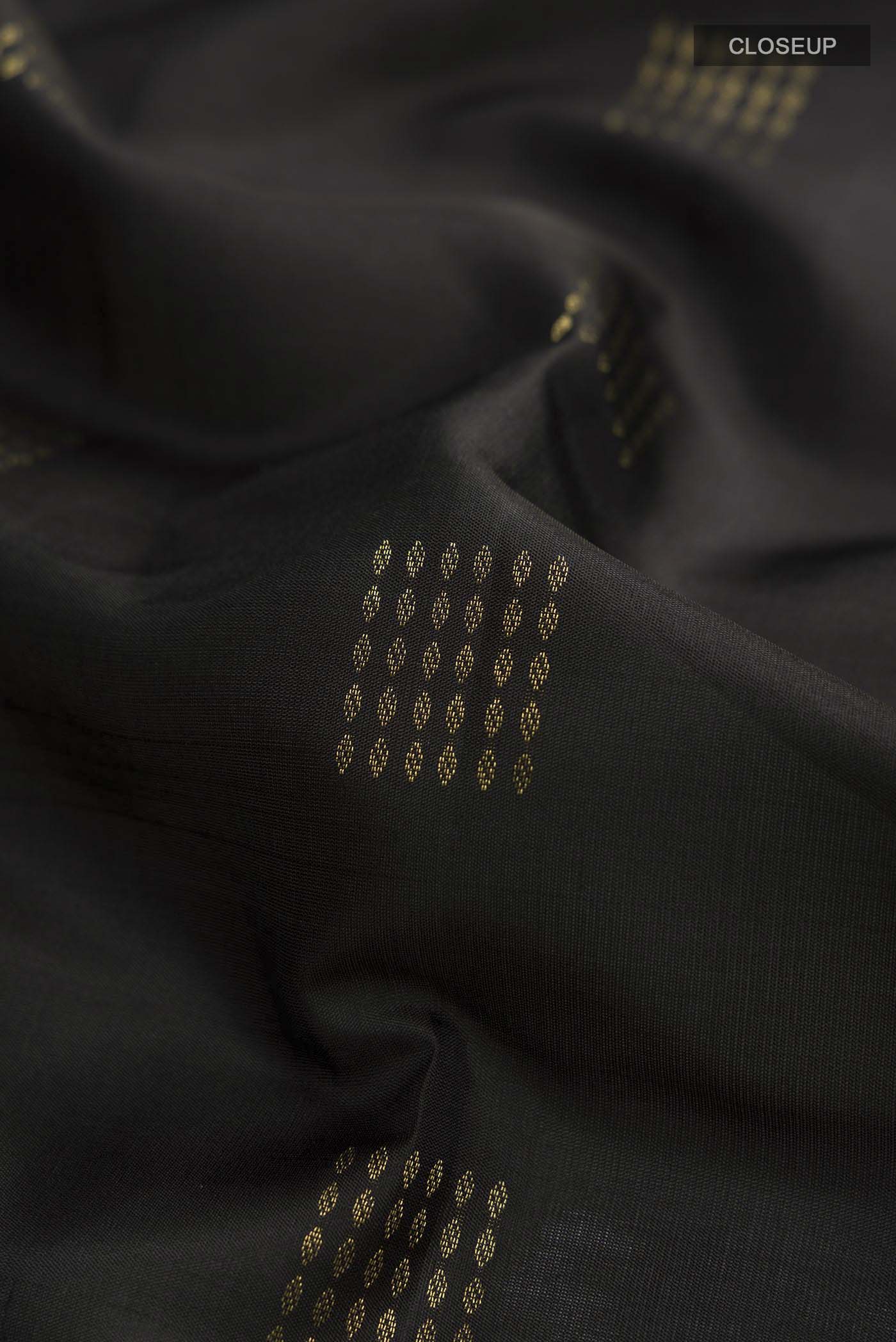 Close up of Black Soft Silk Saree with Zari Butta on the body and Zari Border displaying folds