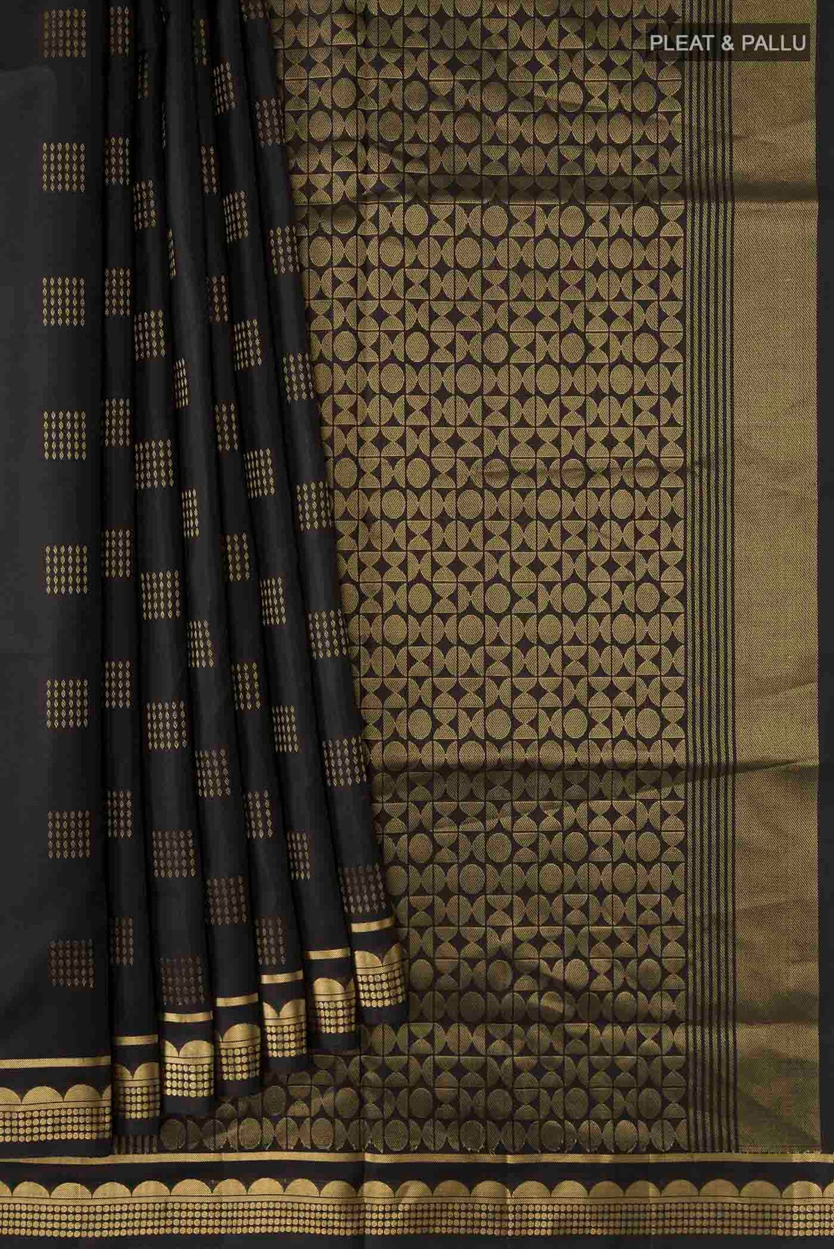 Pleats and pallu of Black Soft Silk Saree with Zari Butta on the body and Zari Border