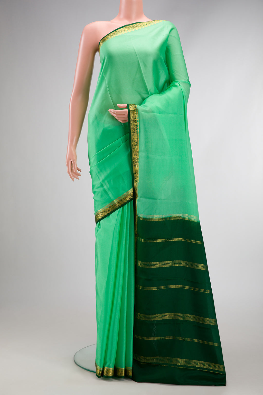 Green Mysore Crepe Saree with Plain Body and Zari Border.  displayed on a mannequin