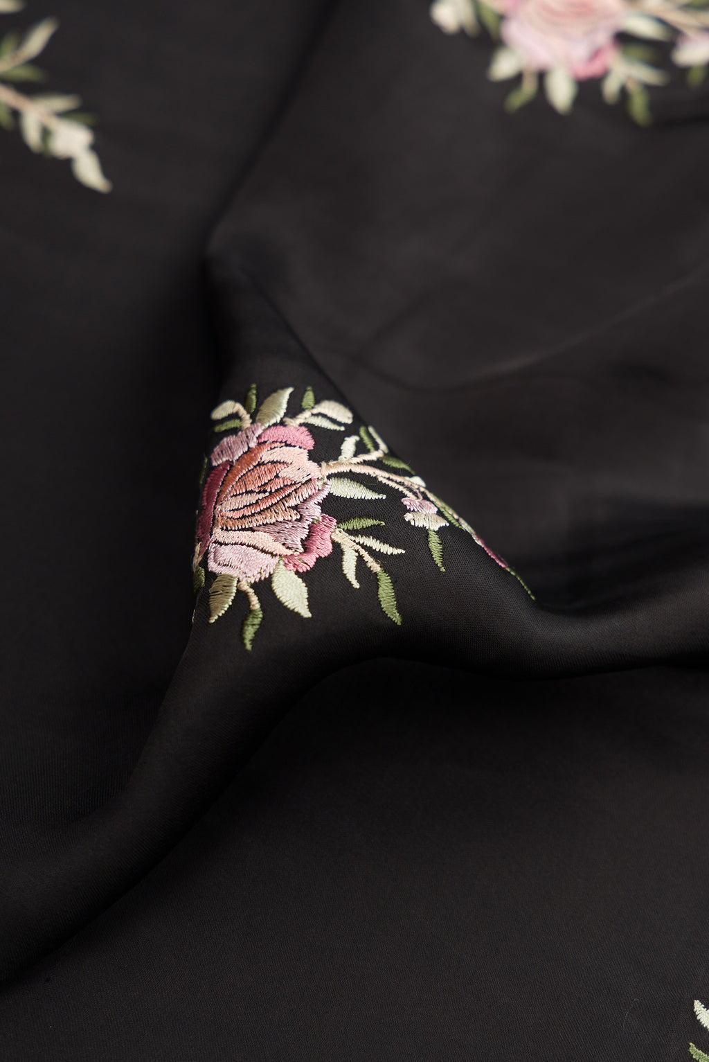 Close up of Black Dual Tone Crepe Saree with Embroidery on the body and Embroidery Border.  displaying folds