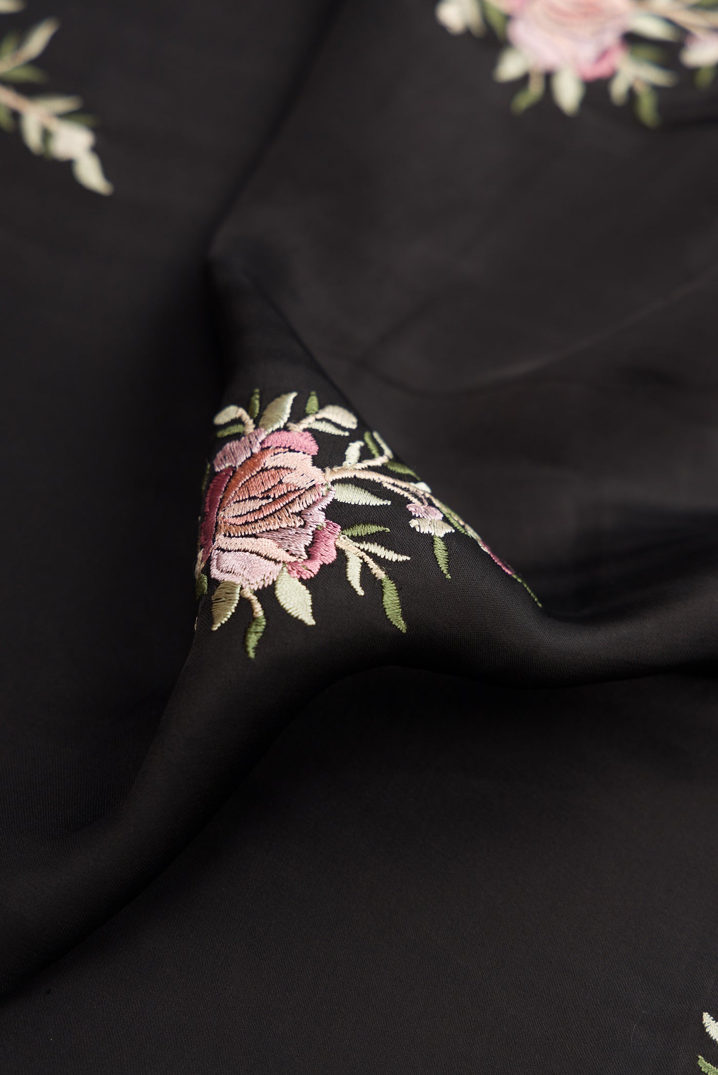 Close up of Black Dual Tone Crepe Saree with Embroidery on the body and Embroidery Border.  displaying folds