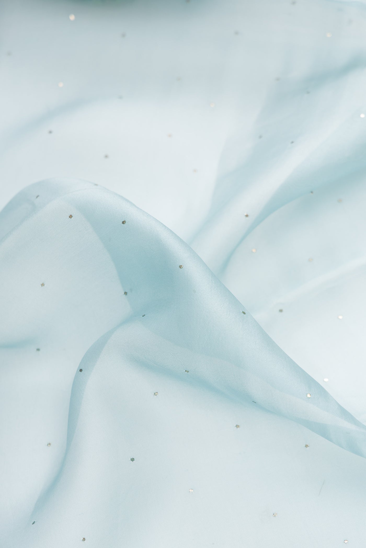 Close up of Sky Blue Dual Tone Organza Silk Saree with Embroidery on the body and Embroidery Border.  displaying folds