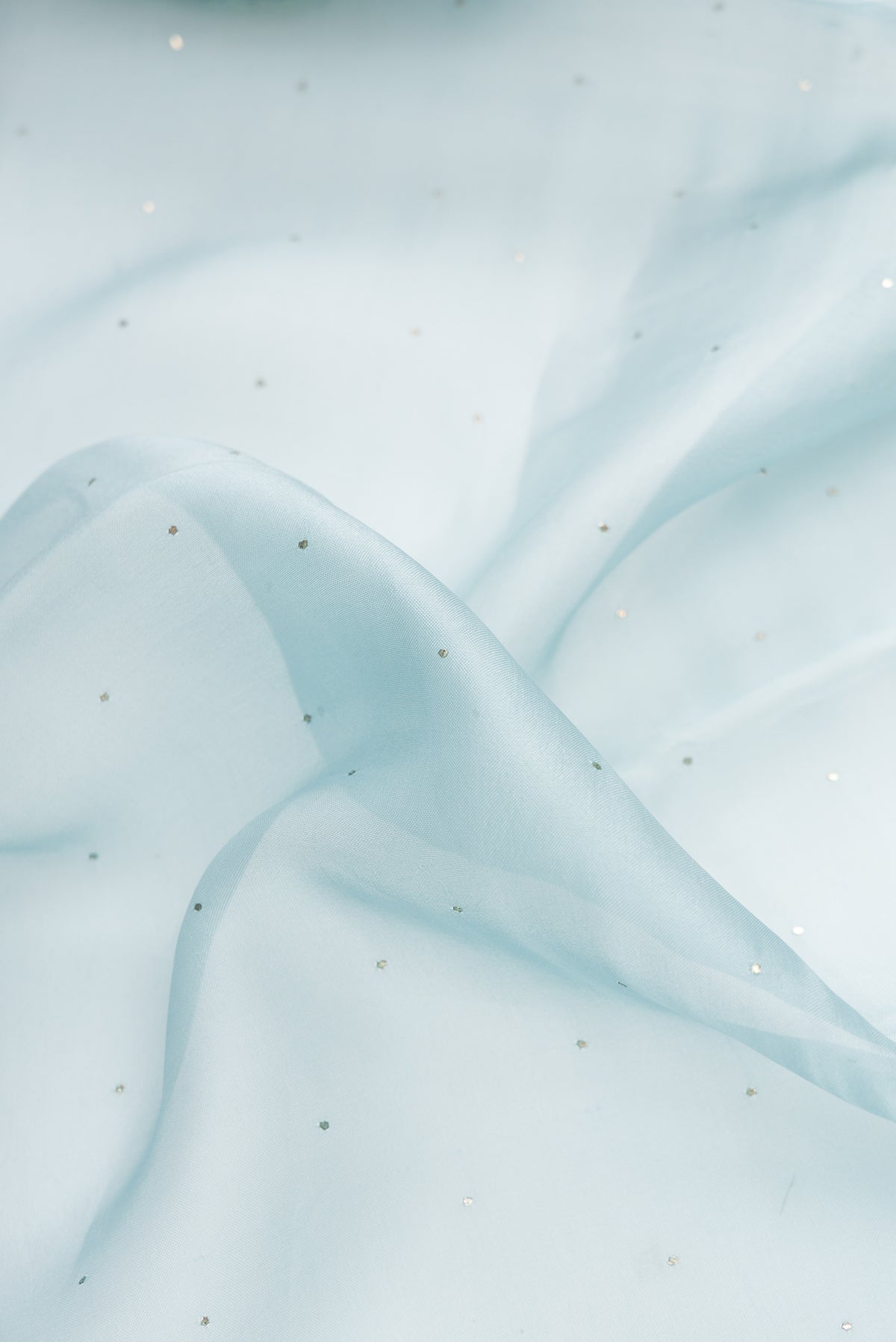 Close up of Sky Blue Dual Tone Organza Silk Saree with Embroidery on the body and Embroidery Border.  displaying folds