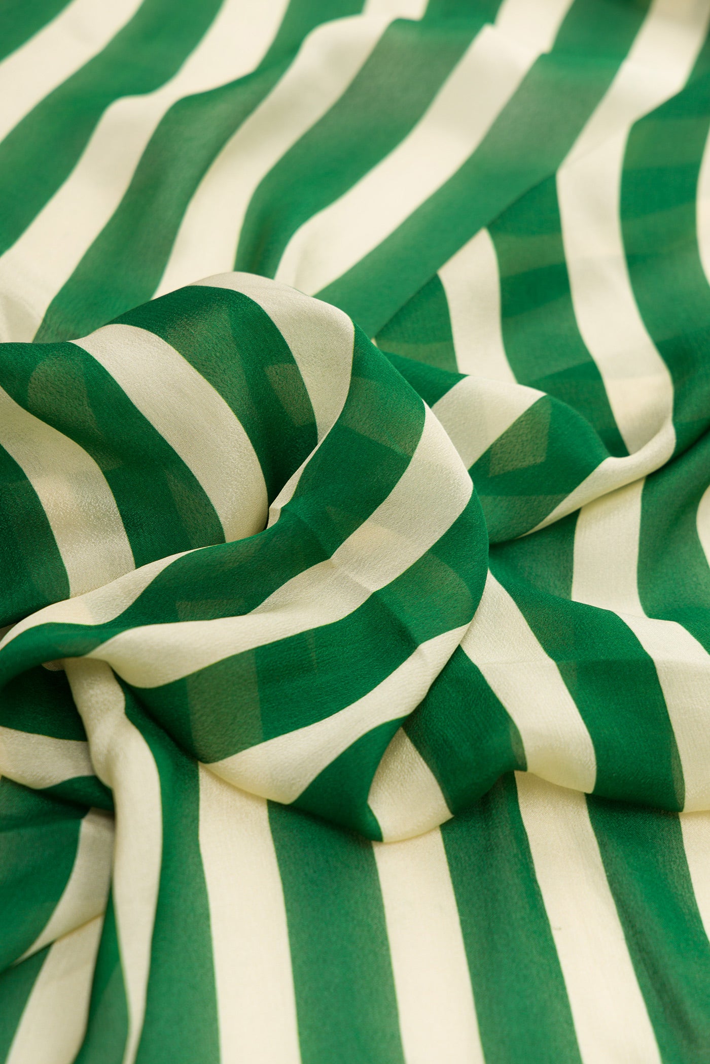 Close up of Beige and Green Color Mysore Crepe Saree with Stripes on the body and Embroidery Border.  displaying folds