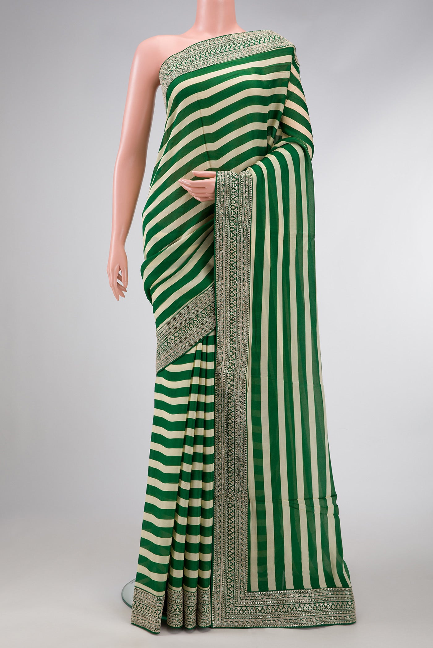 Beige and Green Color Mysore Crepe Saree with Stripes on the body and Embroidery Border.  displayed on a mannequin