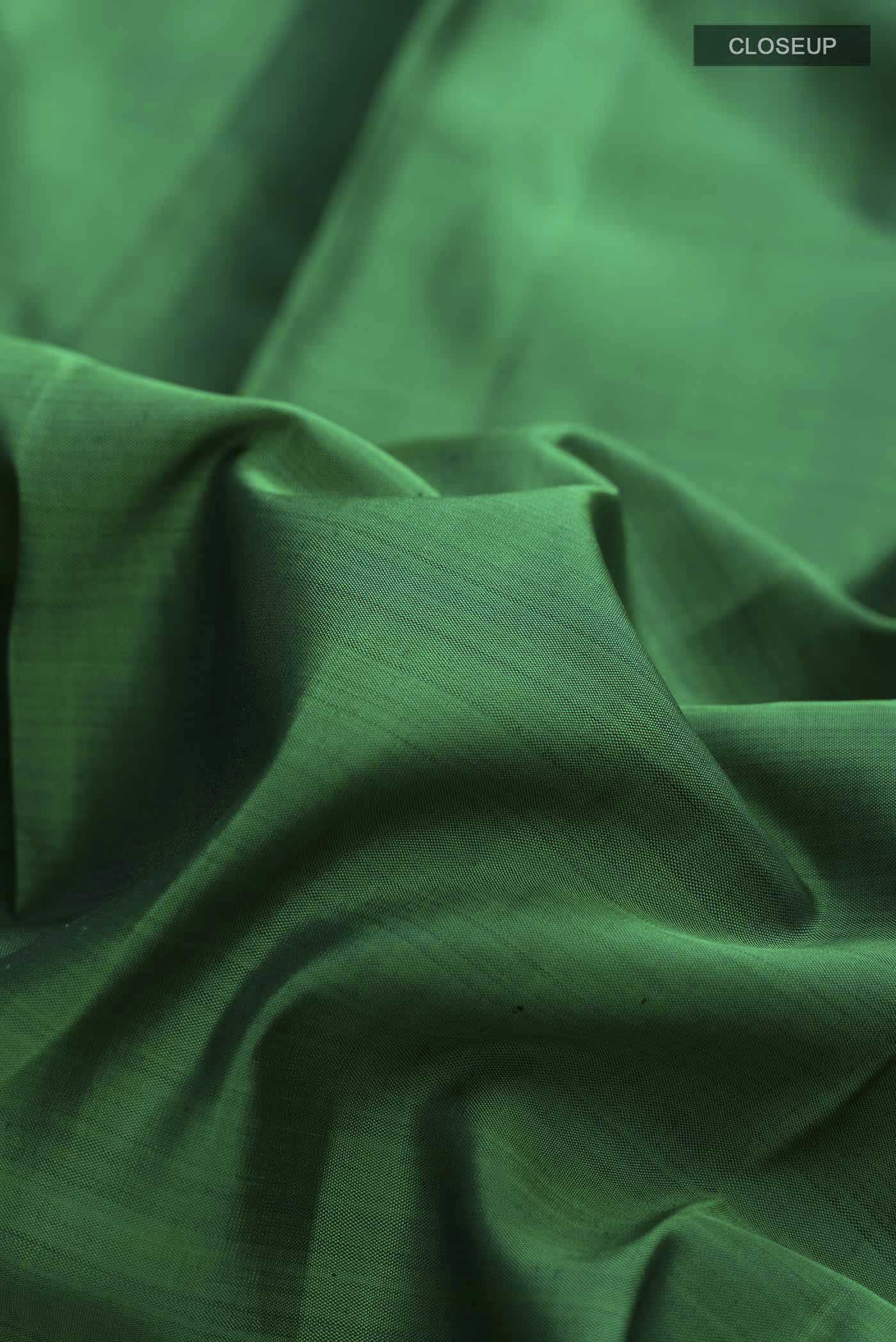 Close up of Green Kanchipuram Silk Saree with Plain Body and Zari Border displaying folds