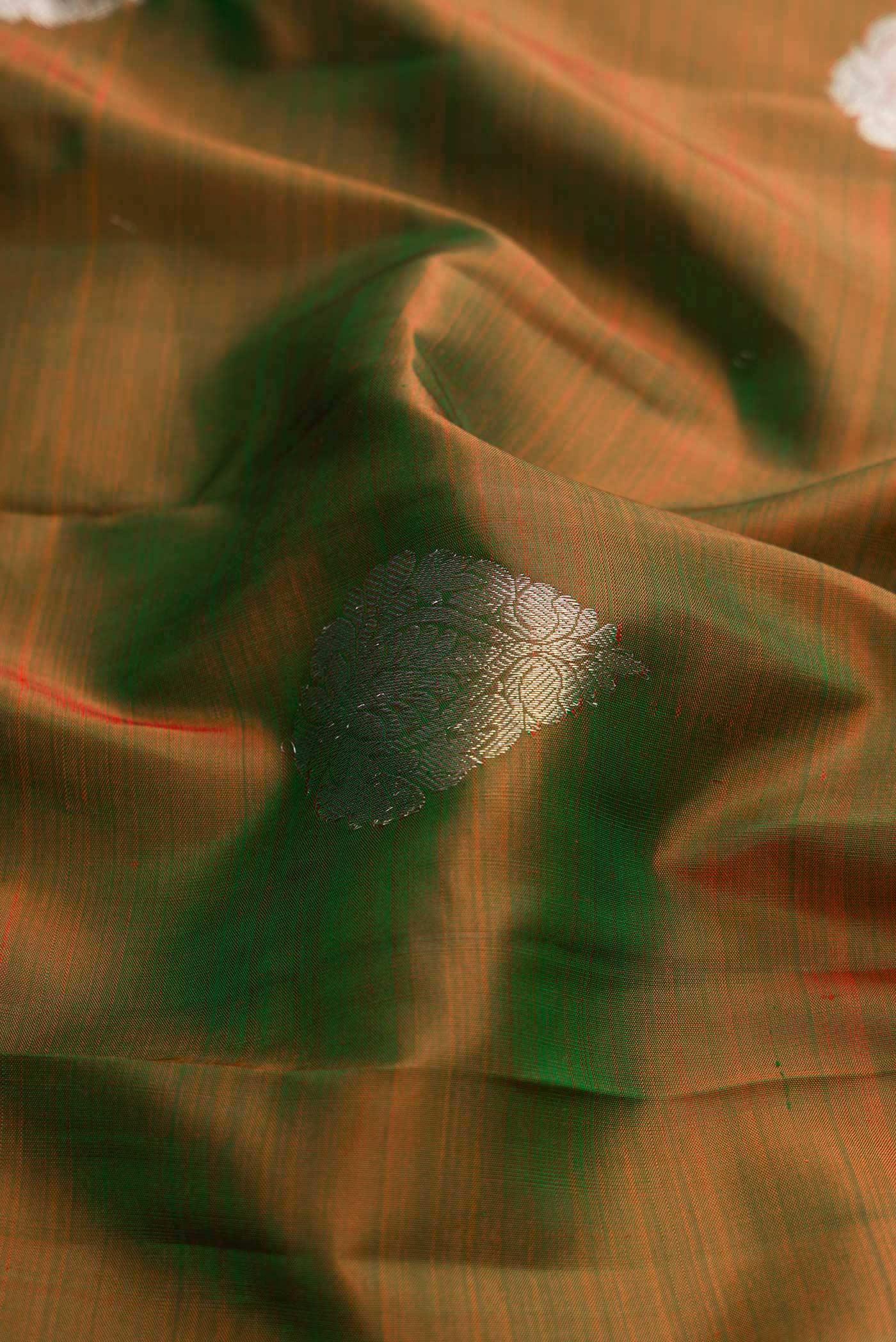 Close up of Green Dual Tone Kanchipuram Silk Saree with Zari Butta on the body and Zari Border displaying folds