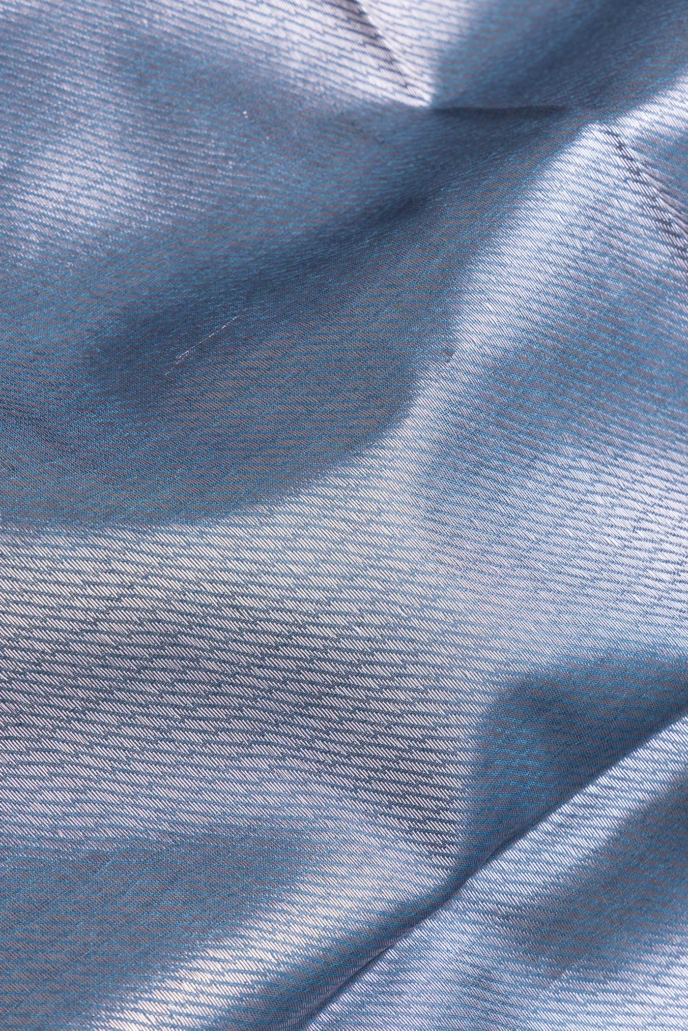 Close up of Peacock Blue Dual Tone Tussar Silk Saree with Thread Butta on the body and Zari Border.  displaying folds