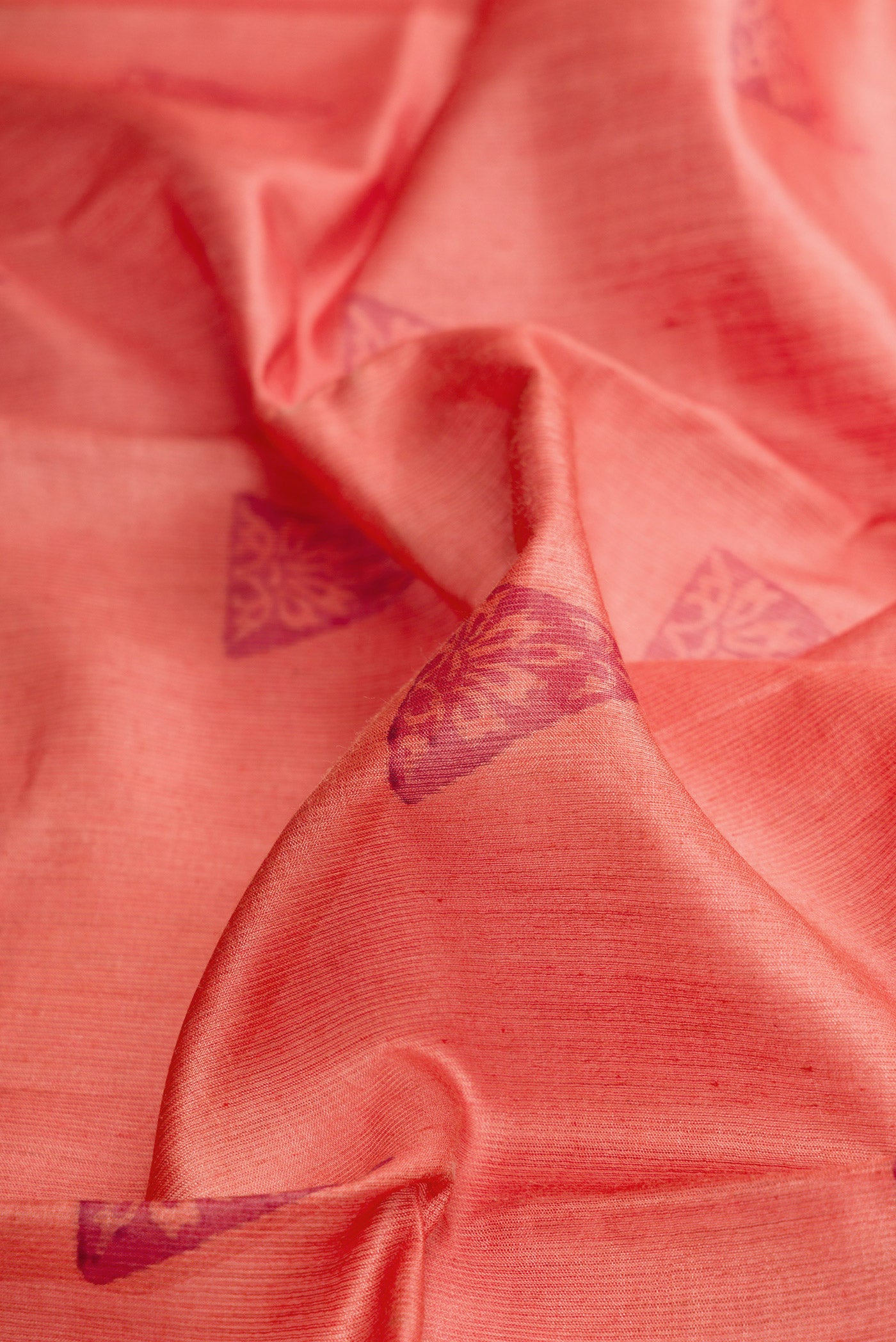 Close up of Brick Orange Dual Tone Tussar Silk Saree with Printed design on the body and Fancy Border.  displaying folds