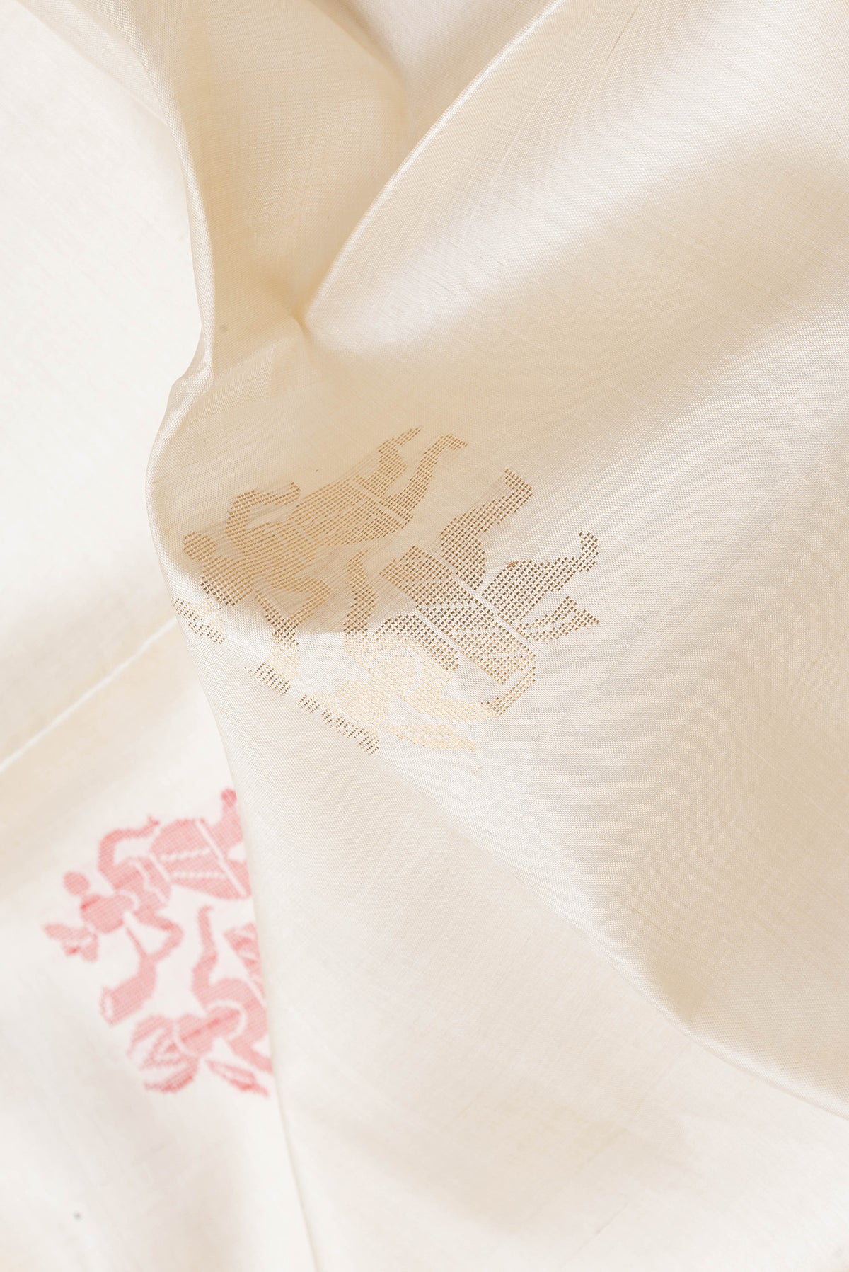 Close up of Cream Tussar Silk Saree with Zari And Thread Butta on the body and Zari Border.  displaying folds