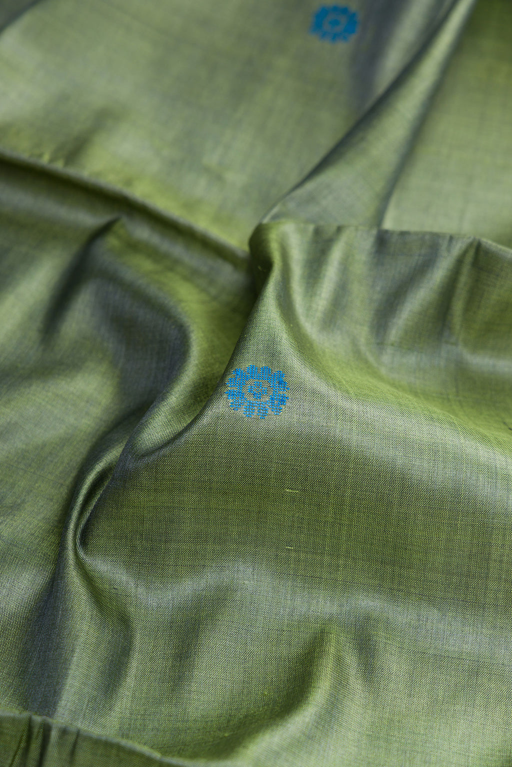 Close up of Mehandi Green Dual Tone Tussar Silk Saree with Thread Butta on the body and Zari Border.  displaying folds