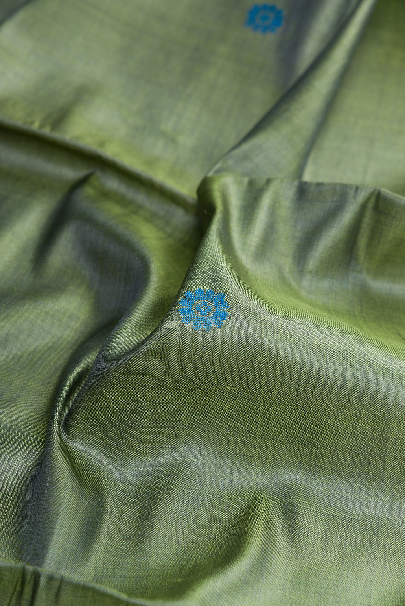 Close up of Mehandi Green Dual Tone Tussar Silk Saree with Thread Butta on the body and Zari Border.  displaying folds