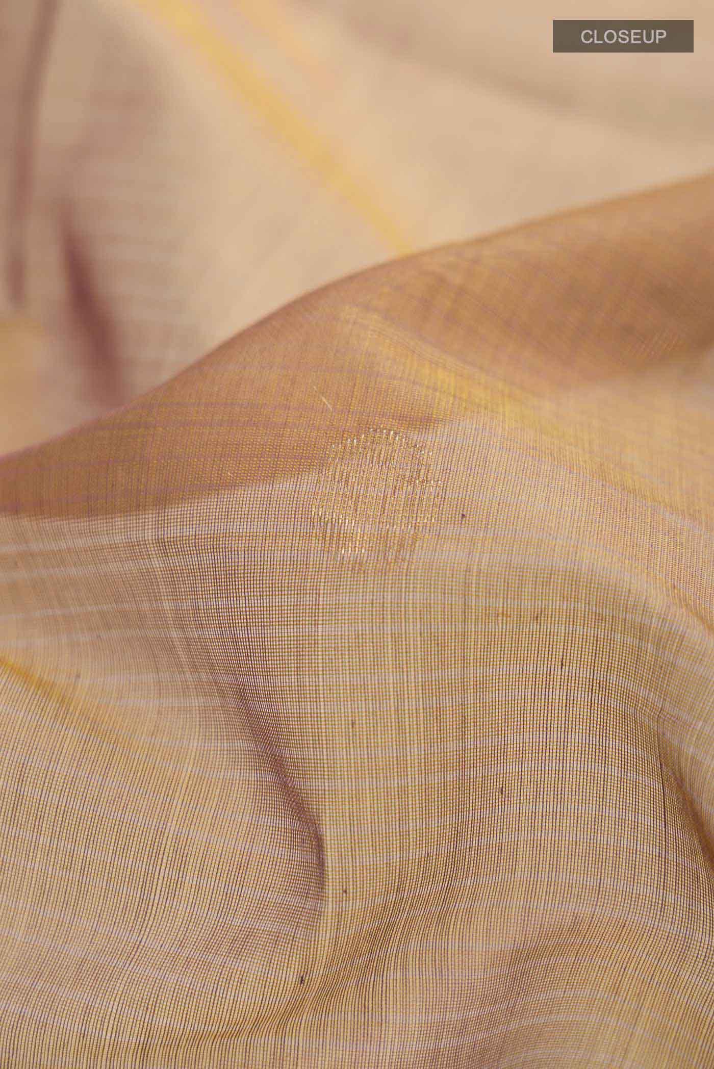 Close up of Brown Silk Cotton Saree with Zari Butta on the body and Zari Border displaying folds