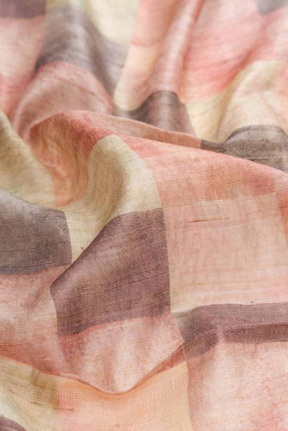Close up of Peach Dual Tone Tussar Silk Saree with Printed design on the body and Zari Border displaying folds