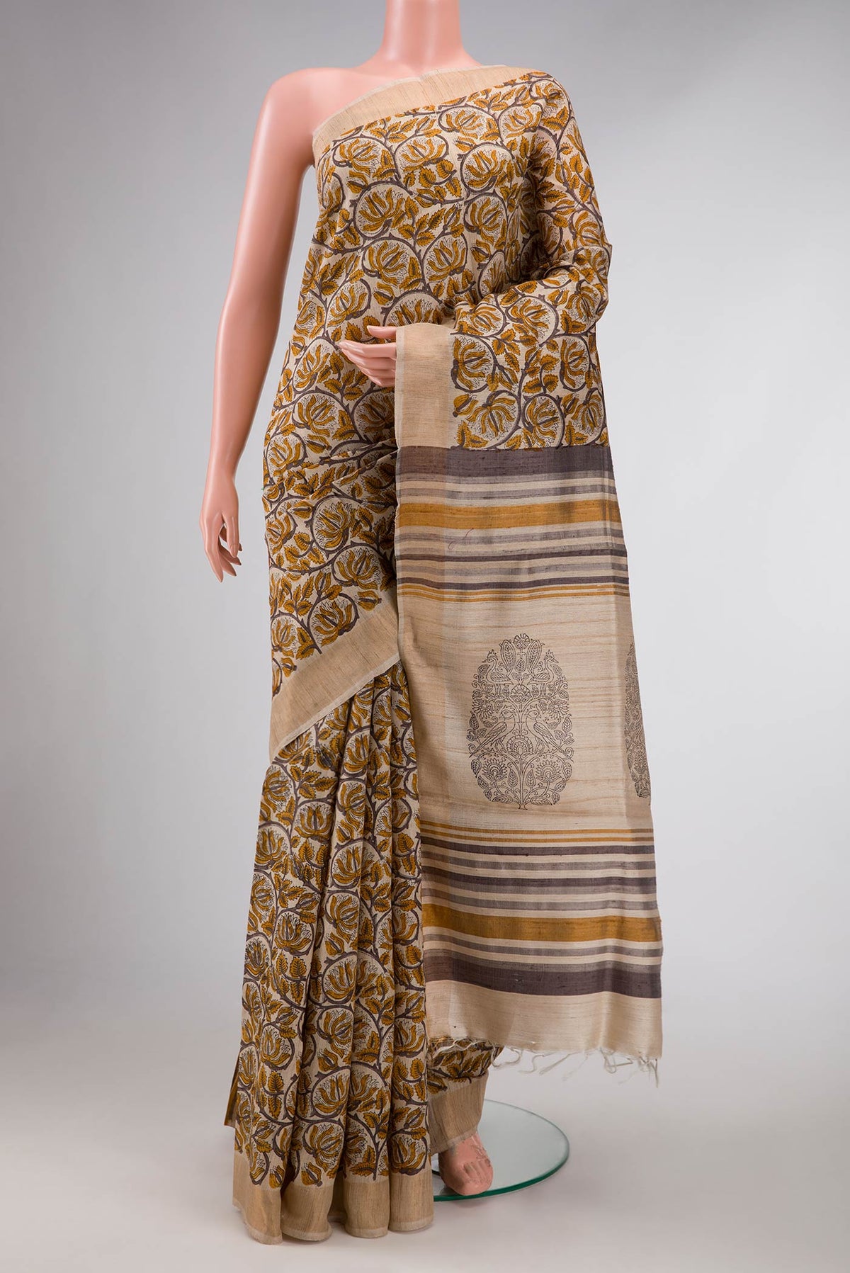 Beige Dual Tone Tussar Silk Saree with Printed design on the body and Zari Border displayed on a mannequin