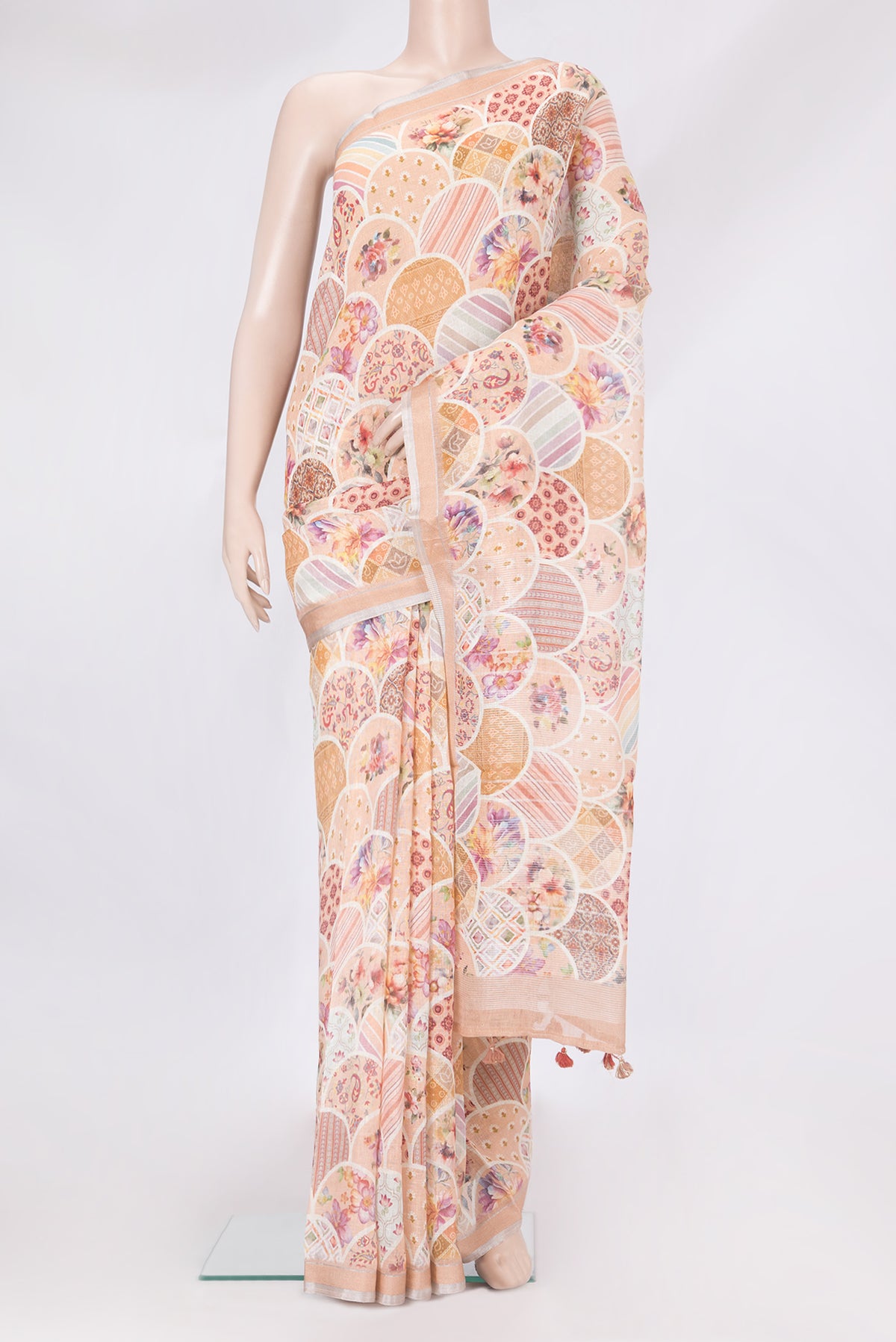 Peach Linen Saree with Printed design on the body and Zari Border.  displayed on a mannequin