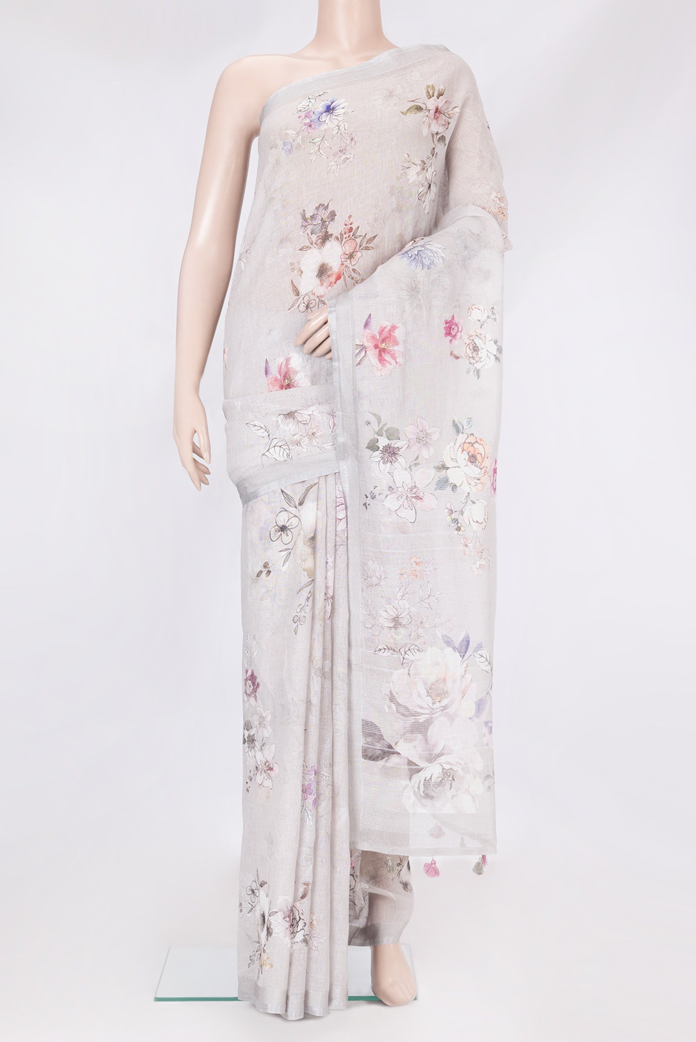 Grey Linen Saree with Floral Print on the body and Zari Border.  displayed on a mannequin