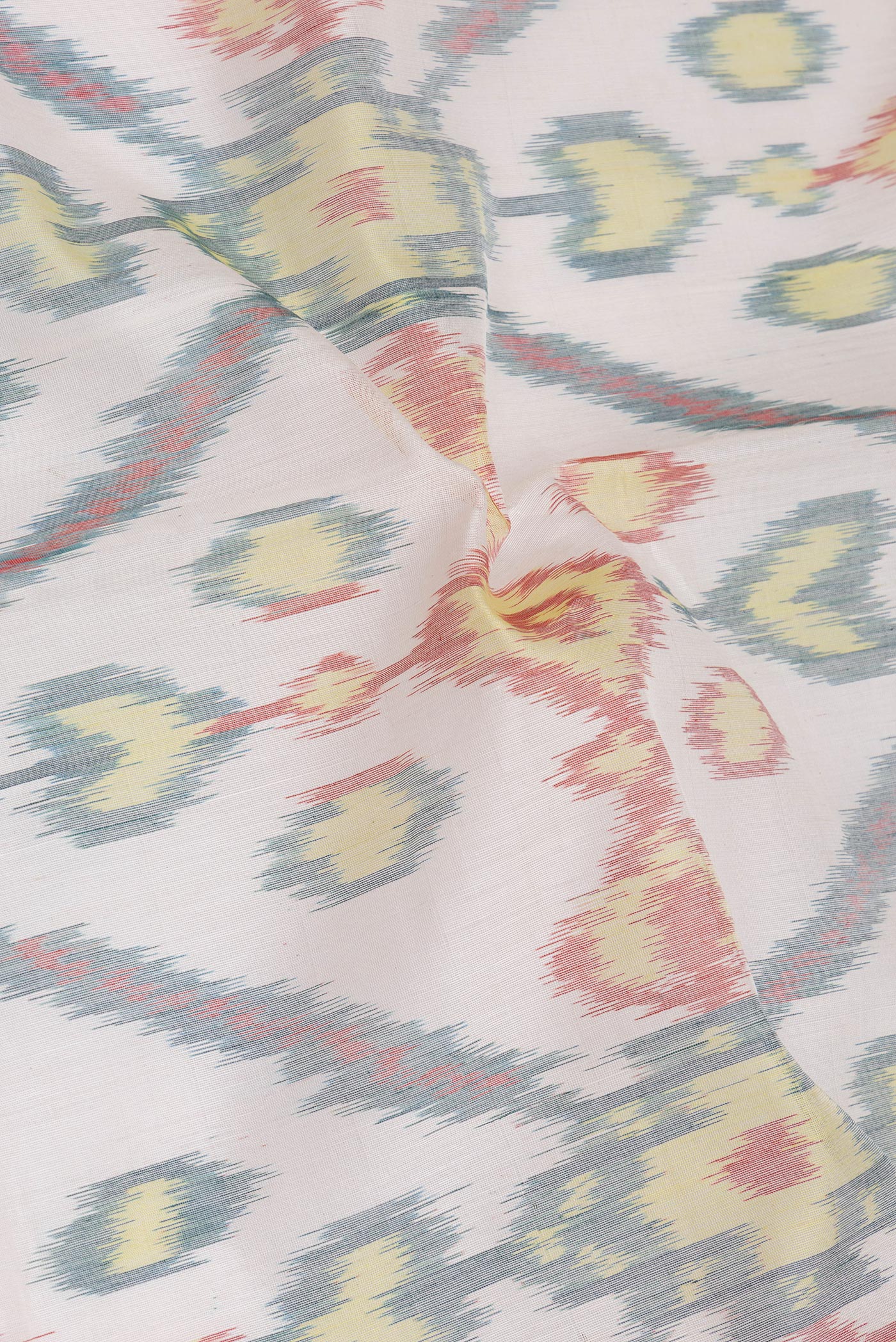Close up of Off White Silk Cotton Saree with Ikat Print on the body and Zari Border.  displaying folds