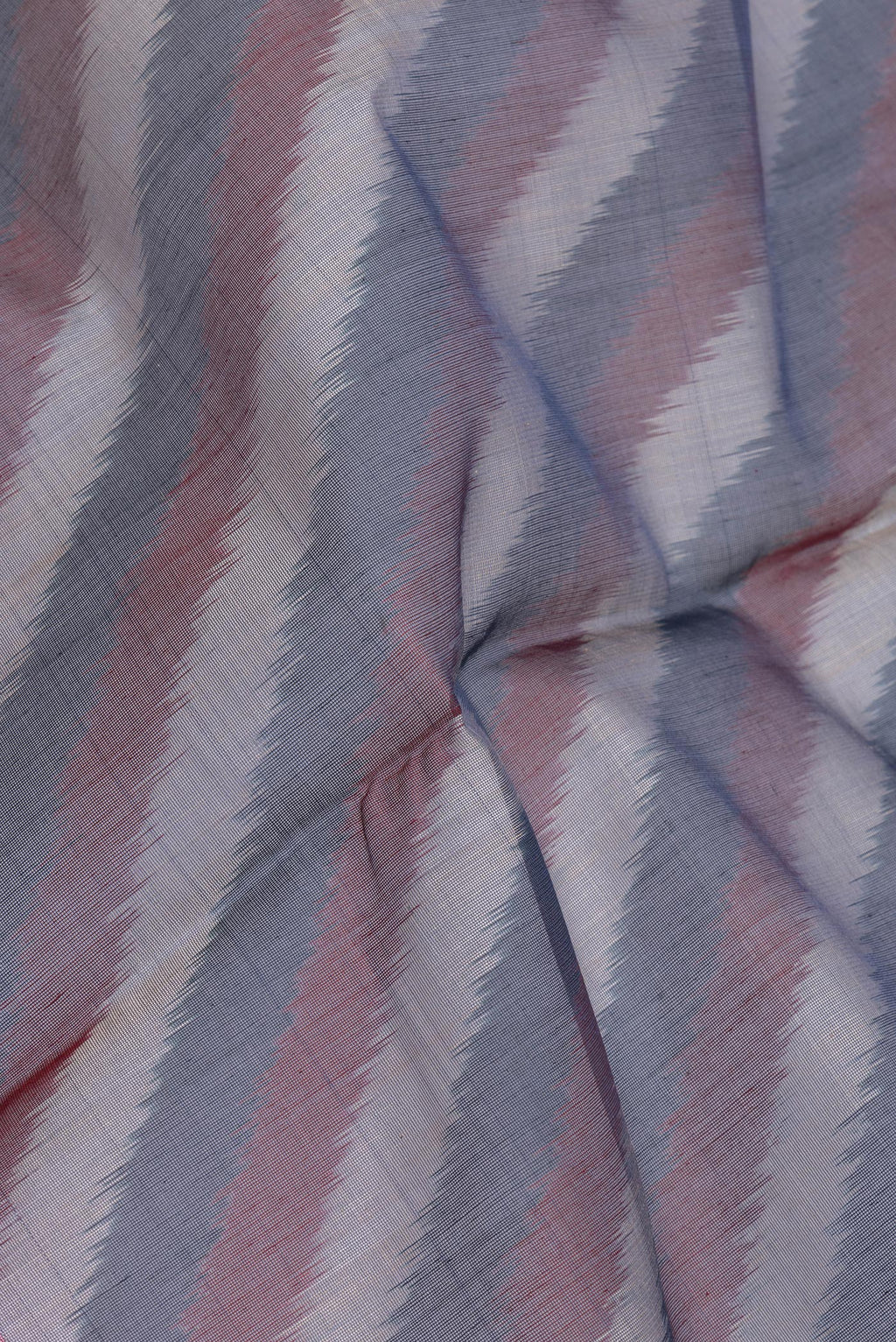 Close up of Peacock Blue Silk Cotton Saree with Ikat Print on the body and Ikat Border.  displaying folds