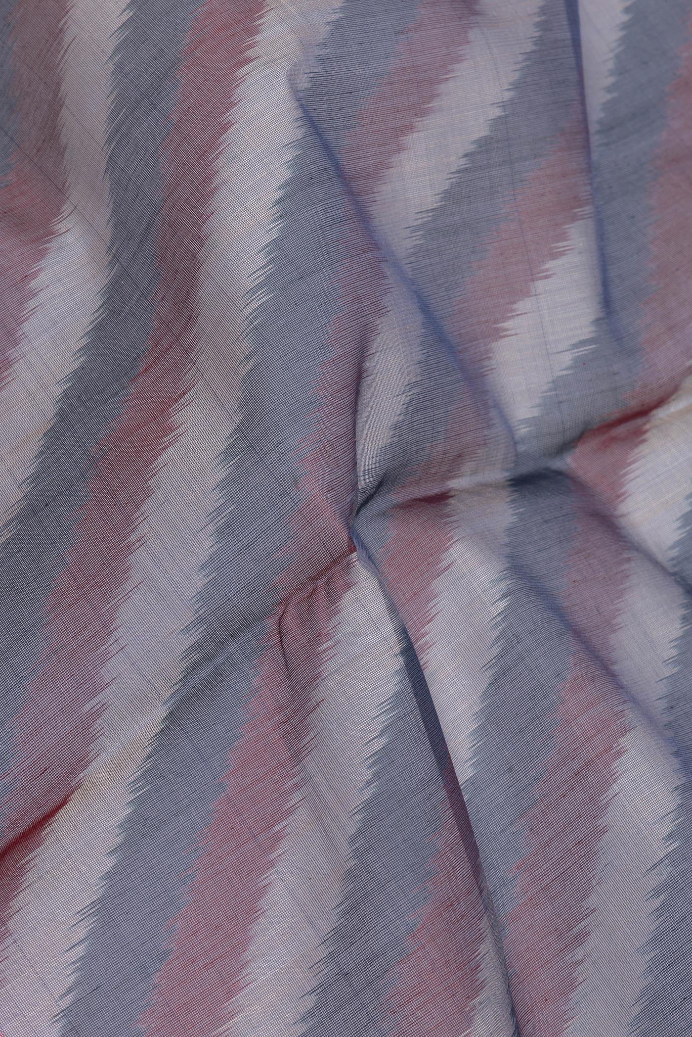 Close up of Peacock Blue Silk Cotton Saree with Ikat Print on the body and Ikat Border.  displaying folds